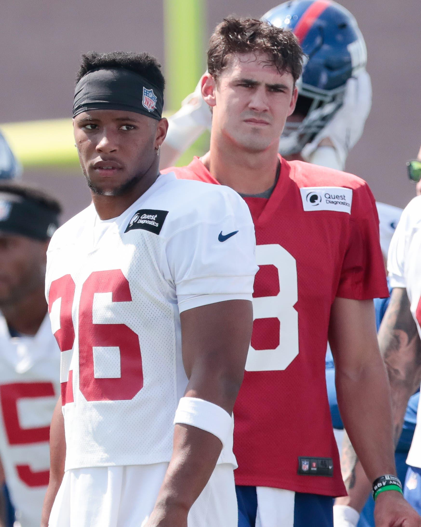 Jul 25, 2019; East Rutherford, NJ, USA; New York Giants running back Saquon Barkley (26) and quarterback Daniel Jones (8) look on during the first day of training camp at Quest Diagnostics Training Center. Mandatory Credit: Vincent Carchietta-USA TODAY Sports / Vincent Carchietta