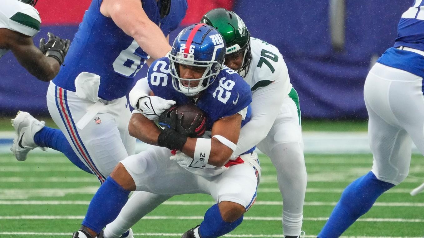 Oct 29, 2023; East Rutherford, New Jersey, USA; New York Jets defensive tackle Quinton Jefferson (70) stops New York Giants running back Saquon Barkley (26) in the first half at MetLife Stadium. / Robert Deutsch-USA TODAY Sports
