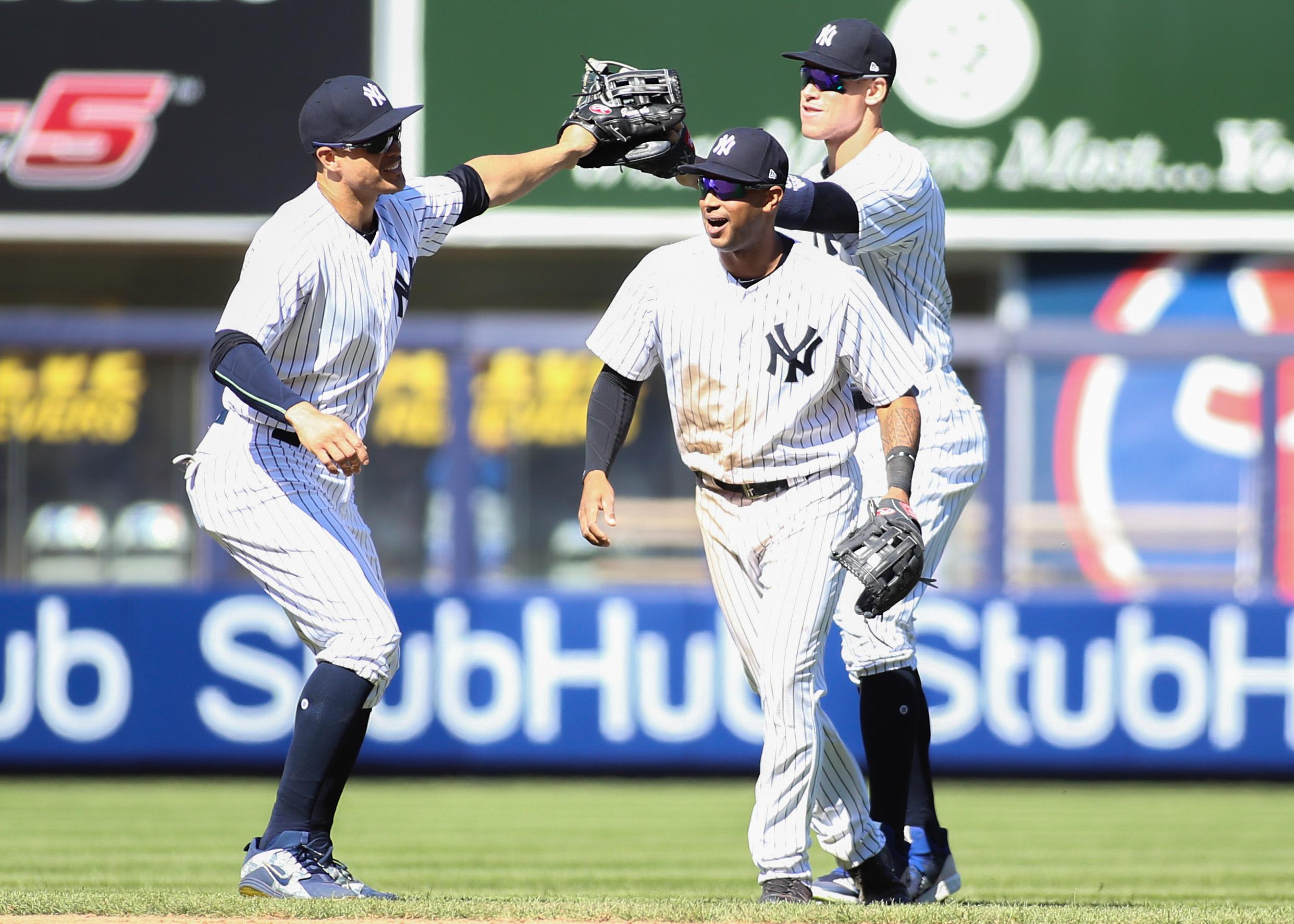 Apr 22, 2018; Bronx, NY, USA; New York Yankees outfielders Giancarlo Stanton (27), Aaron Hicks (31) and Aaron Judge (99) at Yankee Stadium. Mandatory Credit: Wendell Cruz-USA TODAY Sports