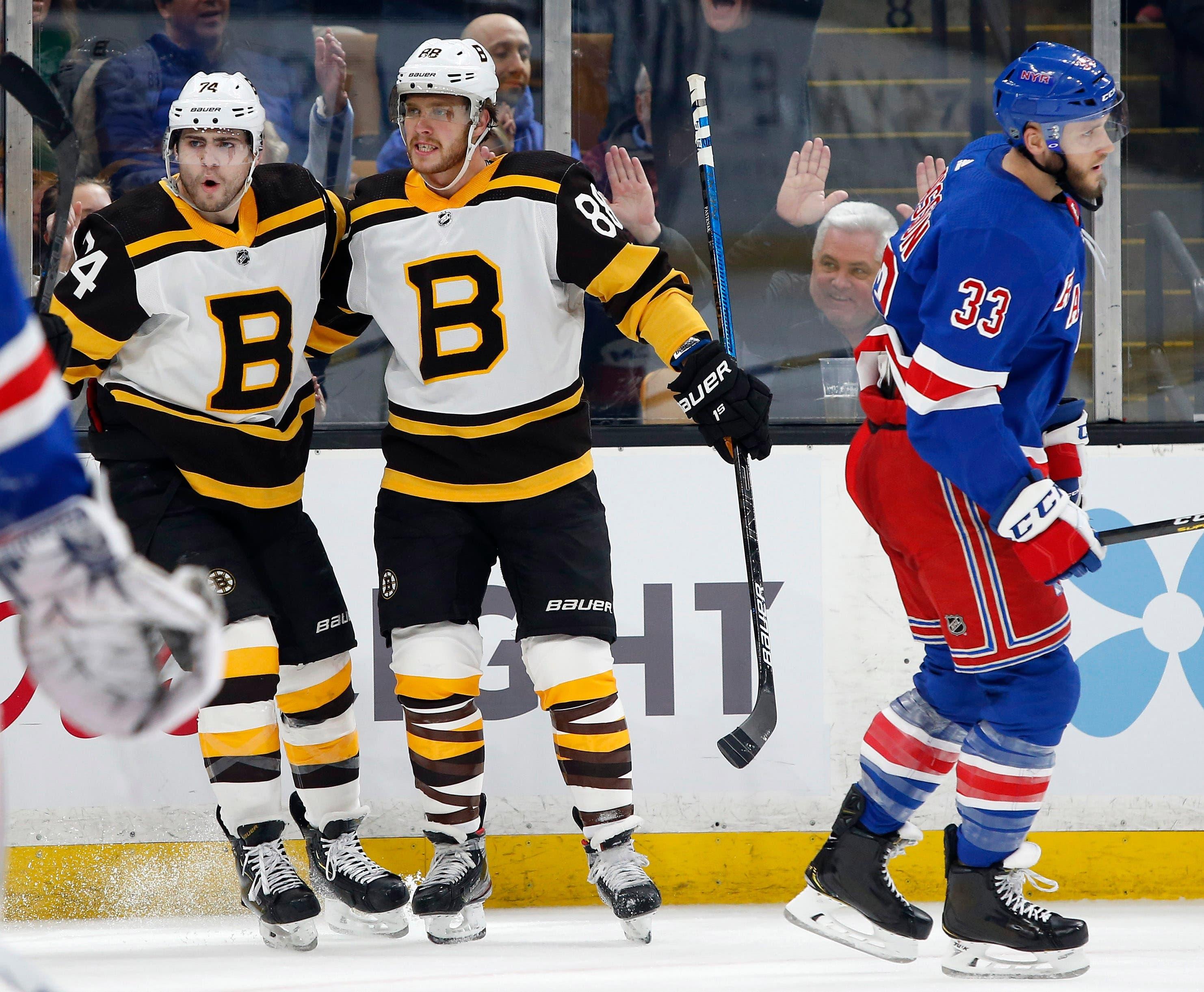 Mar 27, 2019; Boston, MA, USA; Boston Bruins right wing David Pastrnak (88) celebrates his goal with left wing Jake DeBrusk (74) as New York Rangers defenseman Fredrik Claesson (33) skates away during the second period at TD Garden. Mandatory Credit: Winslow Townson-USA TODAY Sports / Winslow Townson