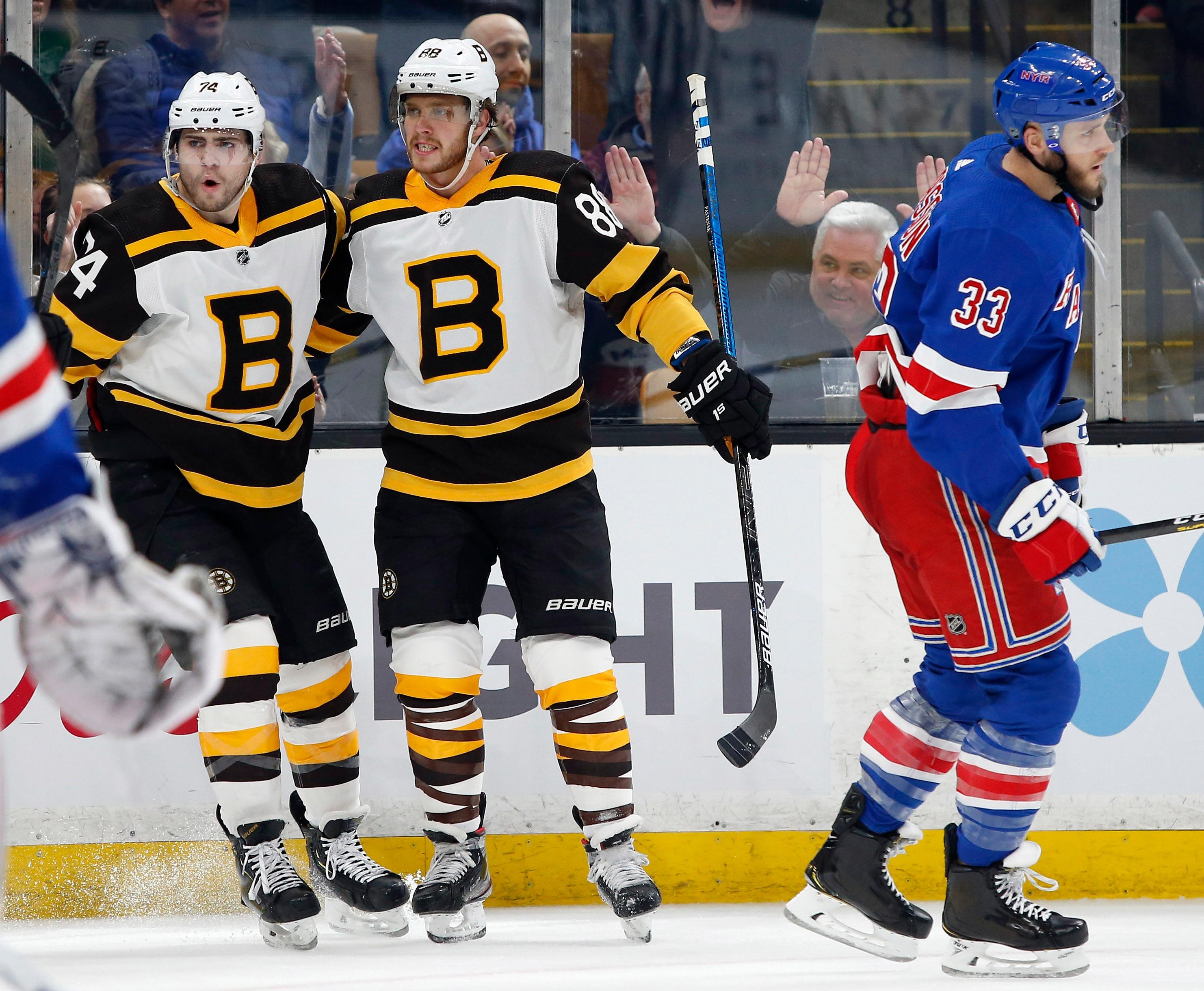 Mar 27, 2019; Boston, MA, USA; Boston Bruins right wing David Pastrnak (88) celebrates his goal with left wing Jake DeBrusk (74) as New York Rangers defenseman Fredrik Claesson (33) skates away during the second period at TD Garden. Mandatory Credit: Winslow Townson-USA TODAY Sports