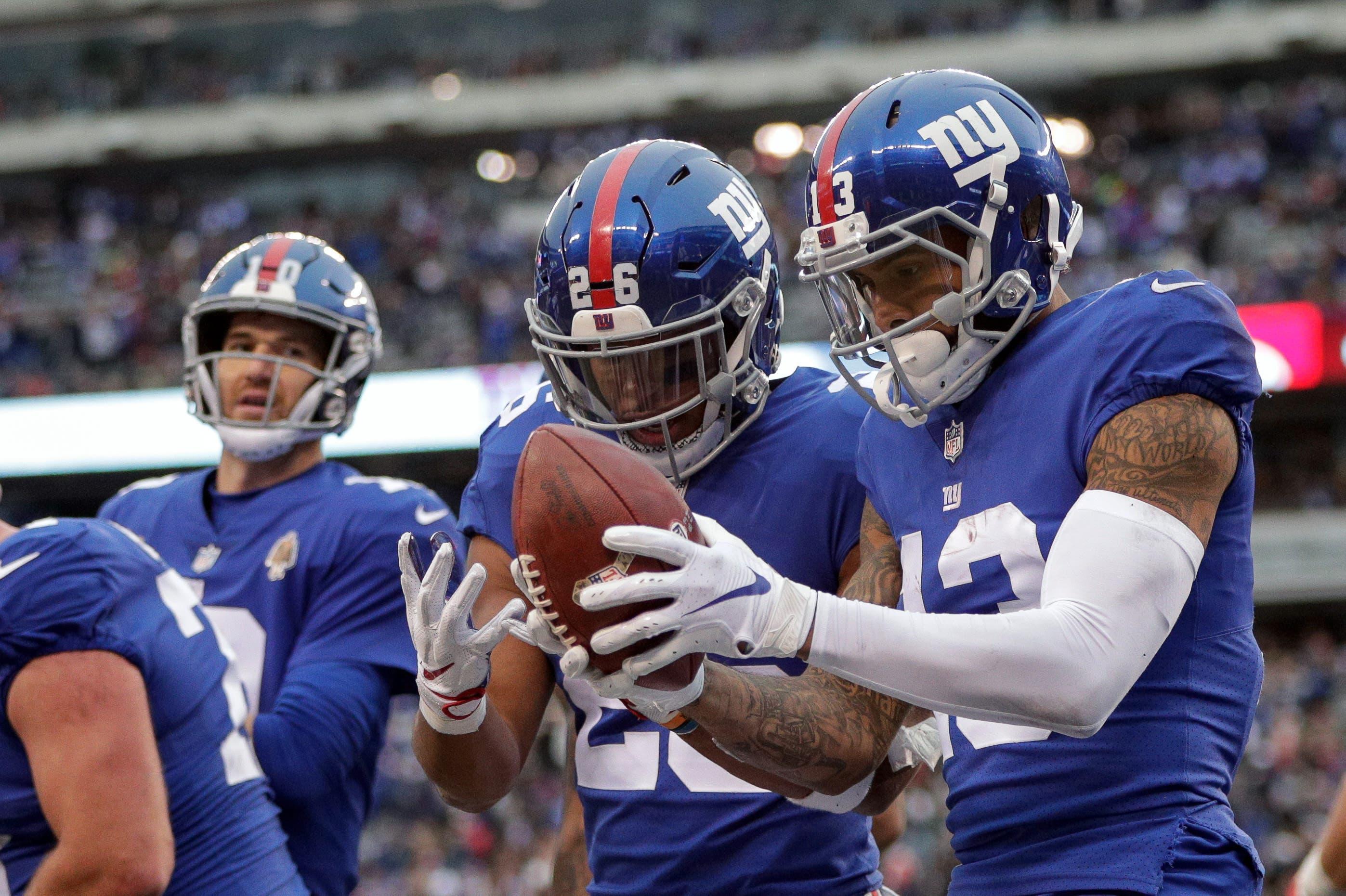 Nov 18, 2018; East Rutherford, NJ, USA; New York Giants wide receiver Odell Beckham (13) celebrates his touchdown with running back Saquon Barkley (26) as quarterback Eli Manning (10) looks on during the second half at MetLife Stadium. Mandatory Credit: Vincent Carchietta-USA TODAY Sports / Vincent Carchietta