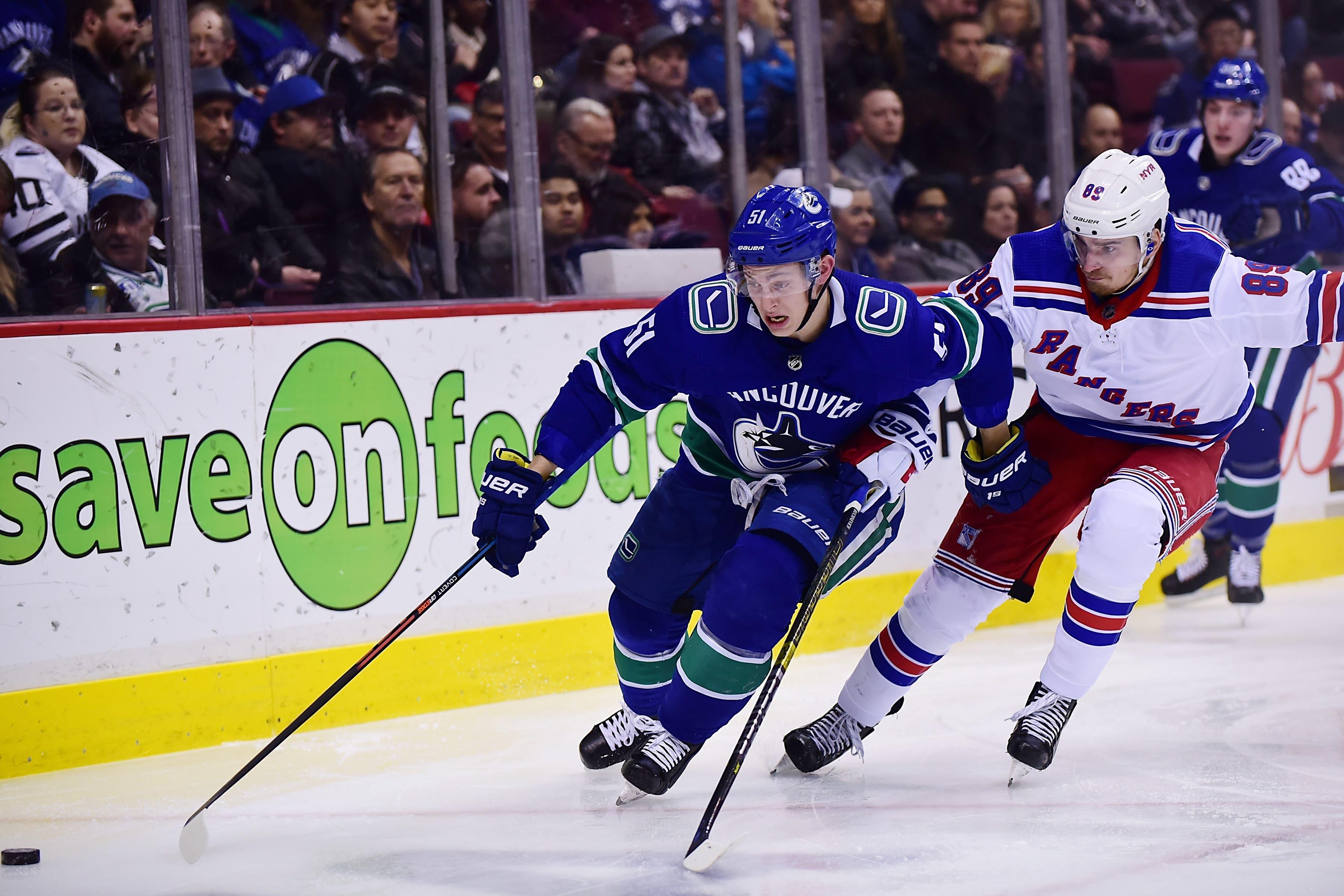 Mar 13, 2019; Vancouver, British Columbia, CAN; Vancouver Canucks defenseman Troy Stecher (51) reaches for the puck against New York Rangers forward Pavel Buchnevich (89) during the second period at Rogers Arena. Mandatory Credit: Anne-Marie Sorvin-USA TODAY Sports / Anne-Marie Sorvin