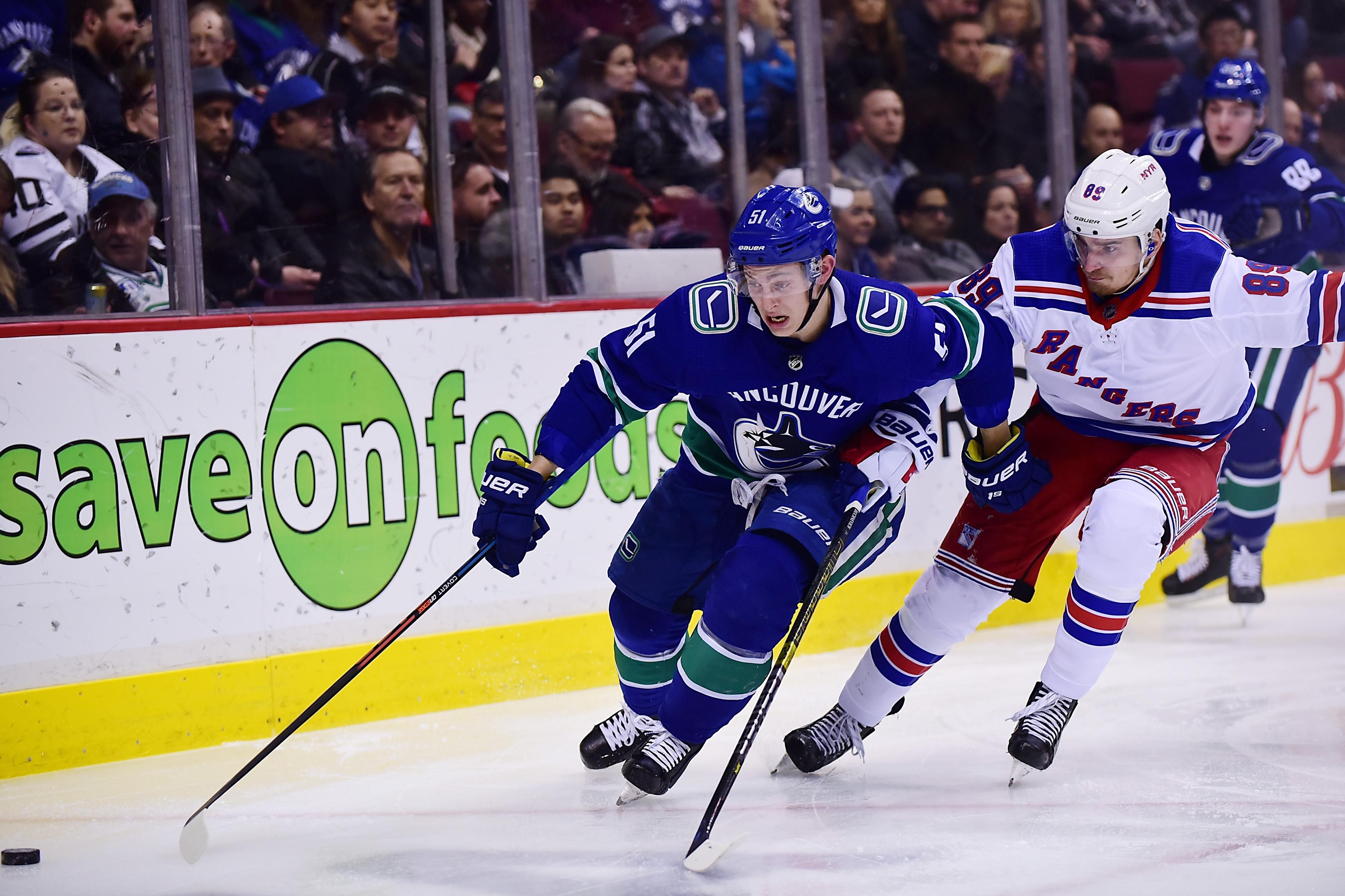 Mar 13, 2019; Vancouver, British Columbia, CAN; Vancouver Canucks defenseman Troy Stecher (51) reaches for the puck against New York Rangers forward Pavel Buchnevich (89) during the second period at Rogers Arena. Mandatory Credit: Anne-Marie Sorvin-USA TODAY Sports