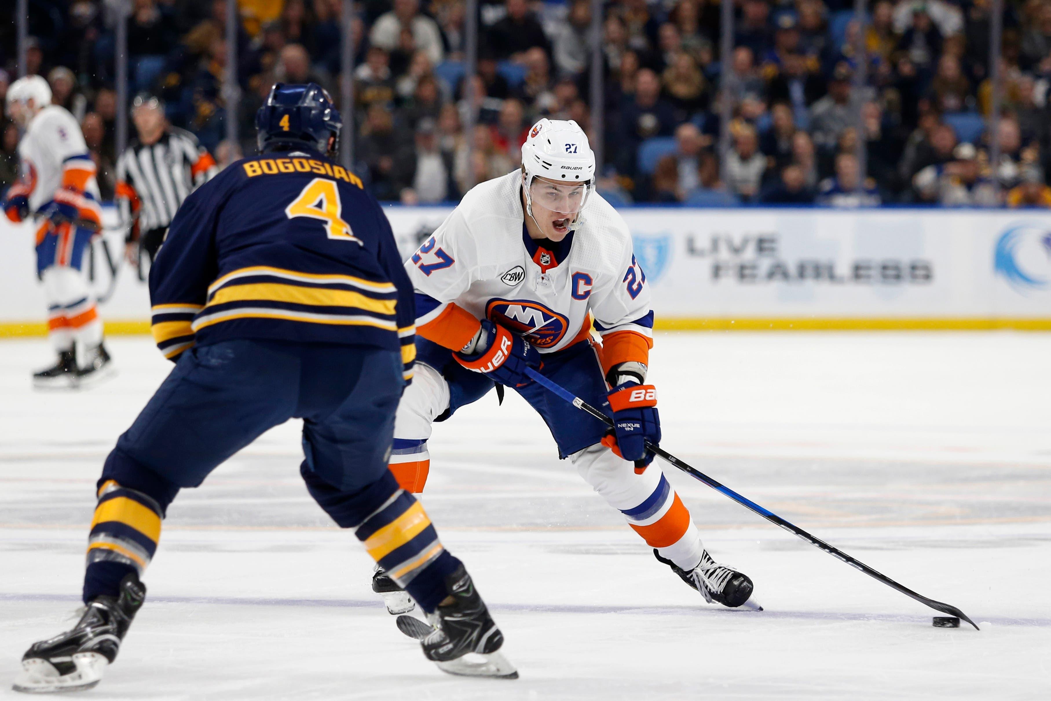 Dec 31, 2018; Buffalo, NY, USA; New York Islanders left wing Anders Lee (27) takes a shot on goal as Buffalo Sabres defenseman Zach Bogosian (4) looks to block it during the first period at KeyBank Center. Mandatory Credit: Timothy T. Ludwig-USA TODAY Sports / Timothy T. Ludwig