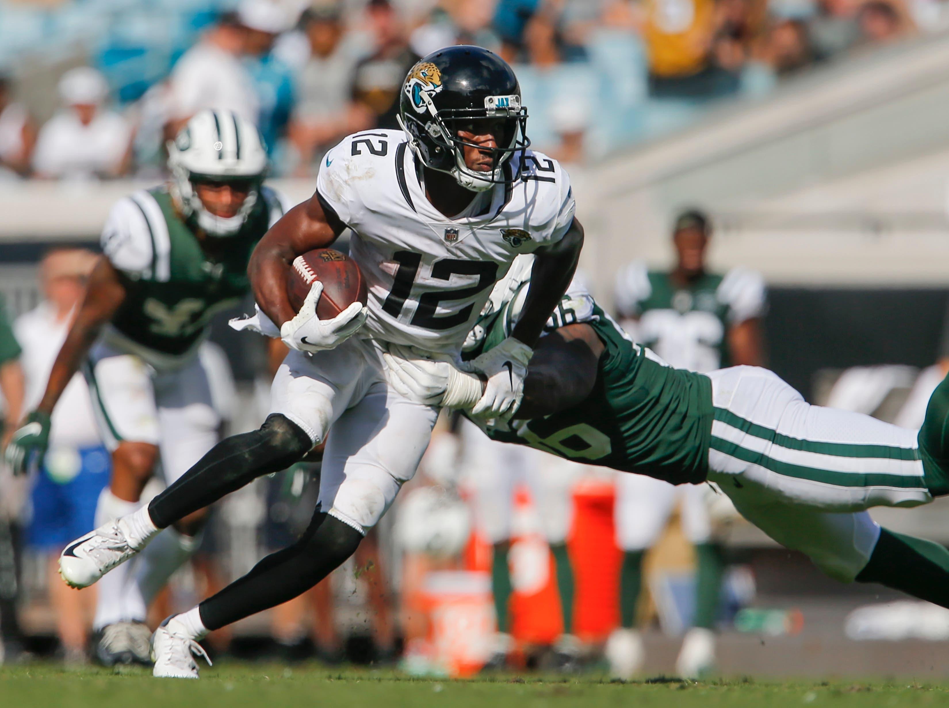 Sep 30, 2018; Jacksonville, FL, USA; Jacksonville Jaguars wide receiver Dede Westbrook (12) slips a tackle by New York Jets linebacker Kevin Pierre-Louis (56) during the second half at TIAA Bank Field. Mandatory Credit: Reinhold Matay-USA TODAY Sports / Reinhold Matay