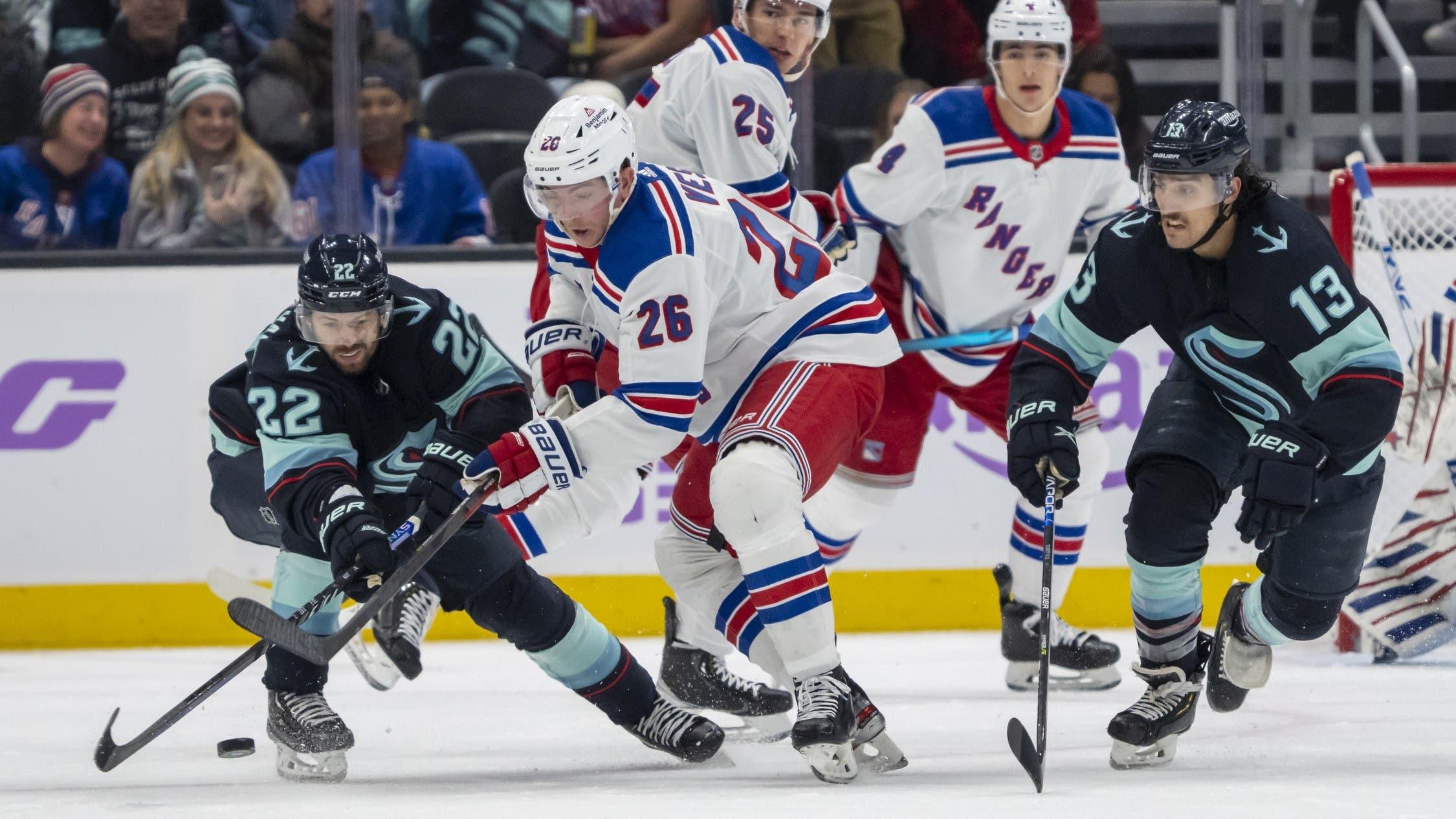 Nov 17, 2022; Seattle, Washington, USA; Seattle Kraken forward Oliver Bjorkstrand (22) and forward Brandon Tanev (13) battle New York Rangers forward Jimmy Vesey (26) for the puck during the second period at Climate Pledge Arena. / Stephen Brashear-USA TODAY Sports