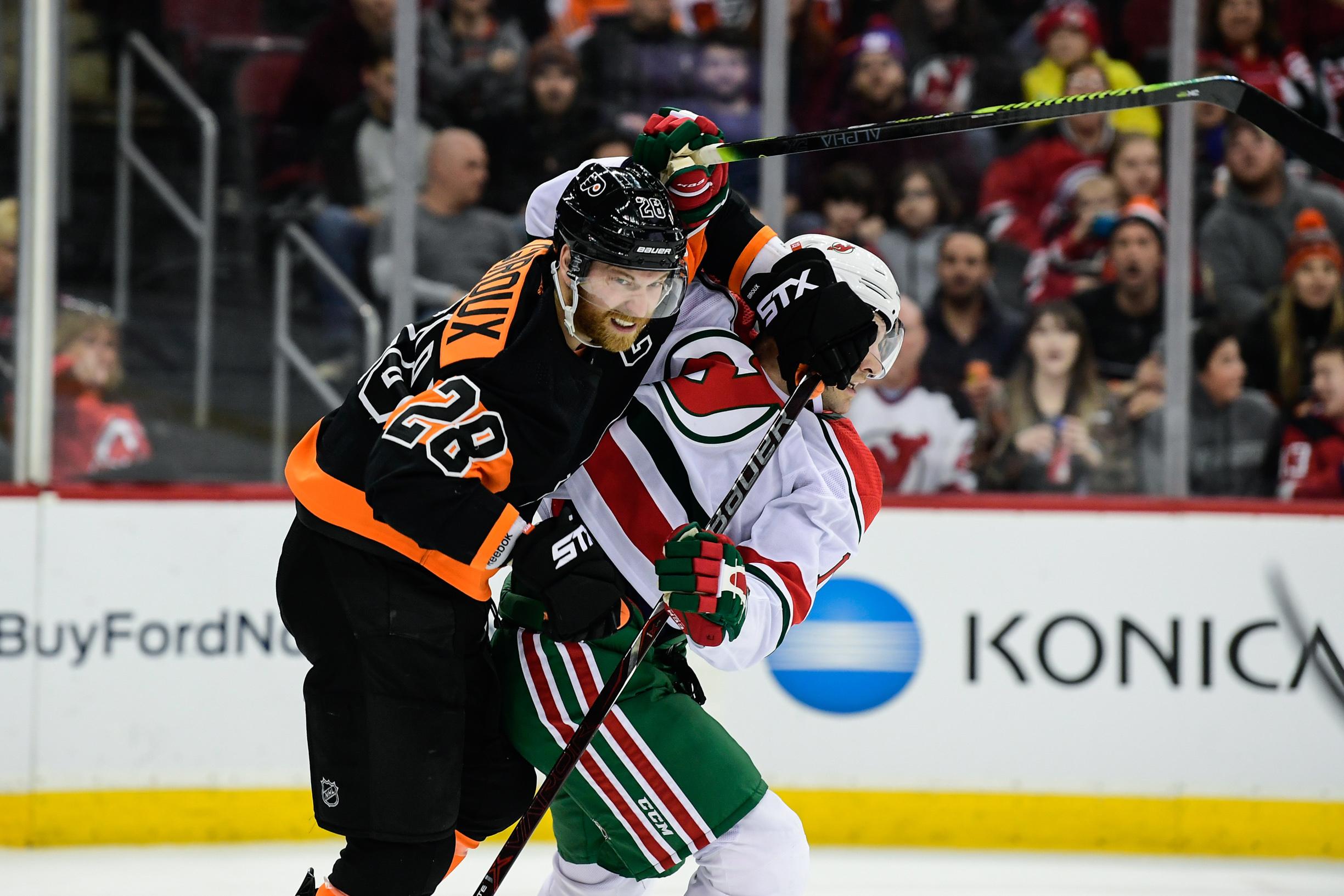 Mar 1, 2019; Newark, NJ, USA; Philadelphia Flyers center Claude Giroux (28) battles with New Jersey Devils left wing Kenny Agostino (17) during the second period at Prudential Center. Mandatory Credit: Catalina Fragoso-USA TODAY Sports