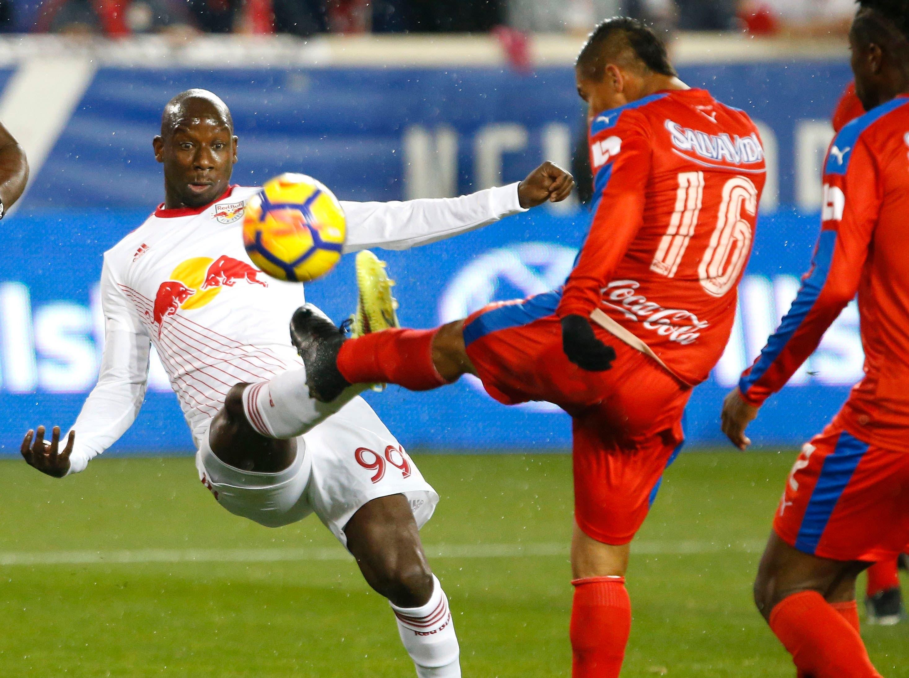 Mar 1, 2018; Harrison, NJ, USA; New York Red Bulls forward Bradley Wright-Phillips (99) battles Club Deportivo Olimpia midfielder Gerson Rodas (16) for the ball during first half at Red Bull Arena. Mandatory Credit: Noah K. Murray-USA TODAY Sports / Noah K. Murray