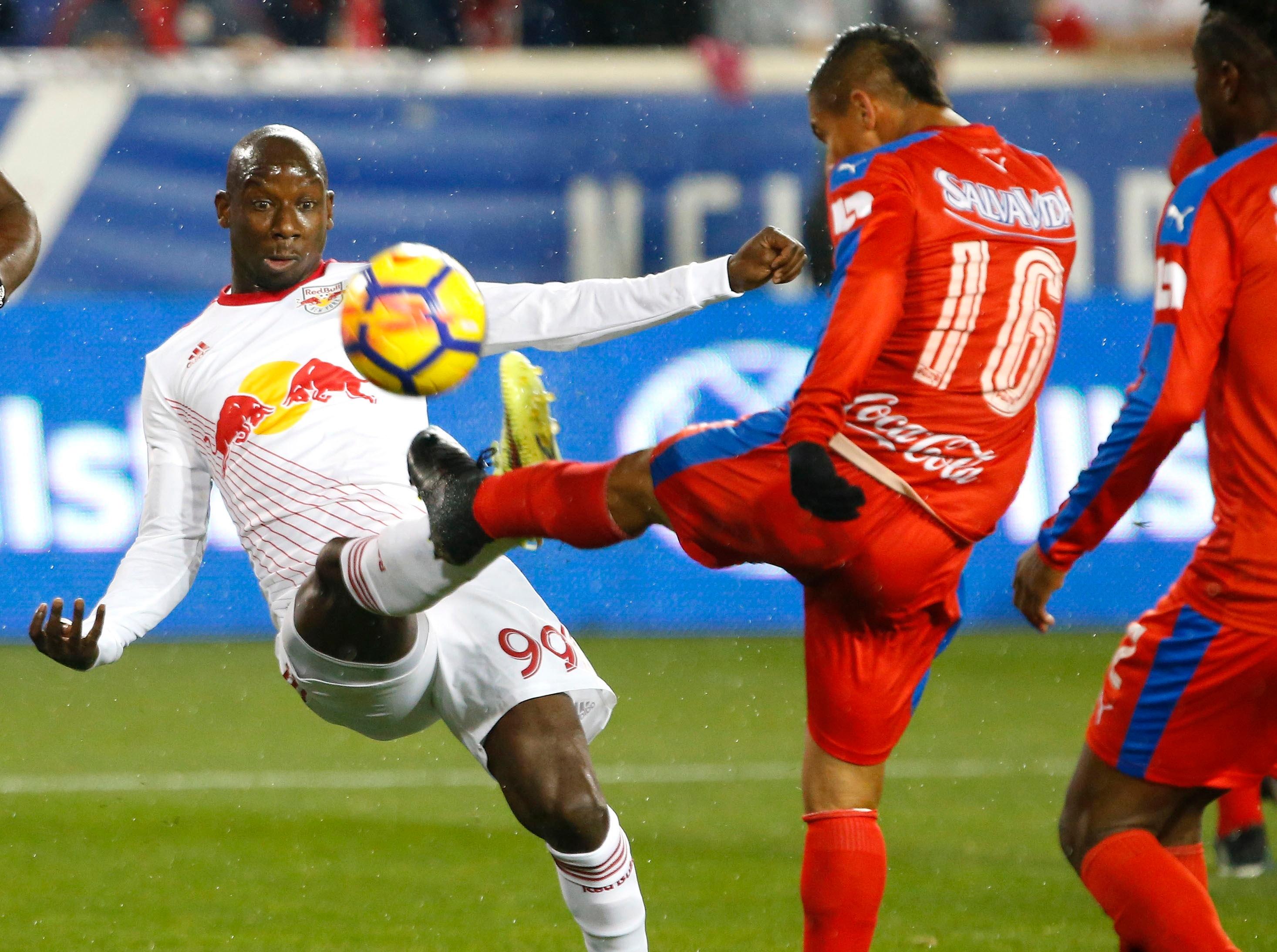 Mar 1, 2018; Harrison, NJ, USA; New York Red Bulls forward Bradley Wright-Phillips (99) battles Club Deportivo Olimpia midfielder Gerson Rodas (16) for the ball during first half at Red Bull Arena. Mandatory Credit: Noah K. Murray-USA TODAY Sports