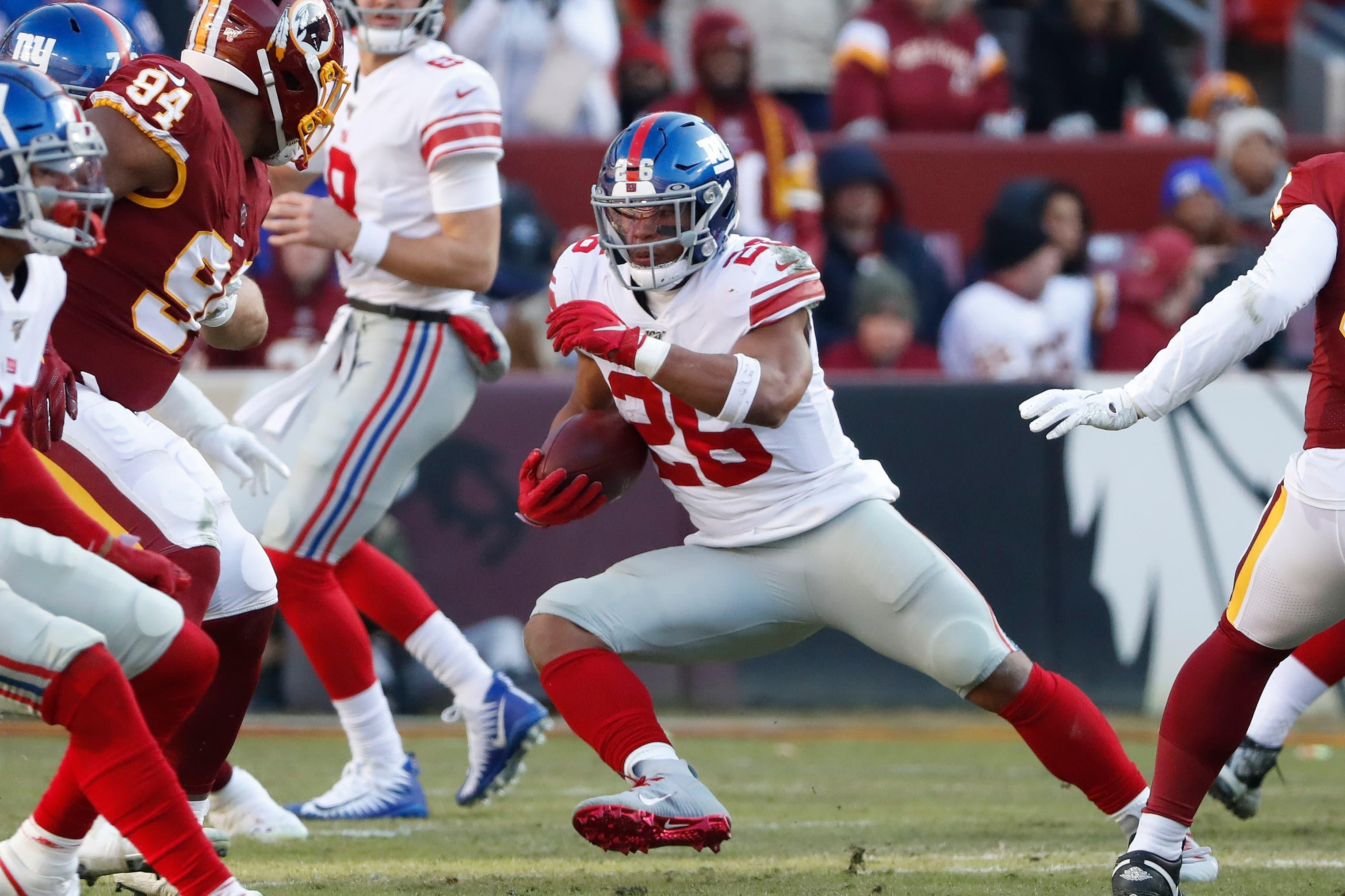 Dec 22, 2019; Landover, Maryland, USA; New York Giants running back Saquon Barkley (26) carries the ball past Washington Redskins nose tackle Daron Payne (94) in the second quarter at FedExField. Mandatory Credit: Geoff Burke-USA TODAY Sports / Geoff Burke