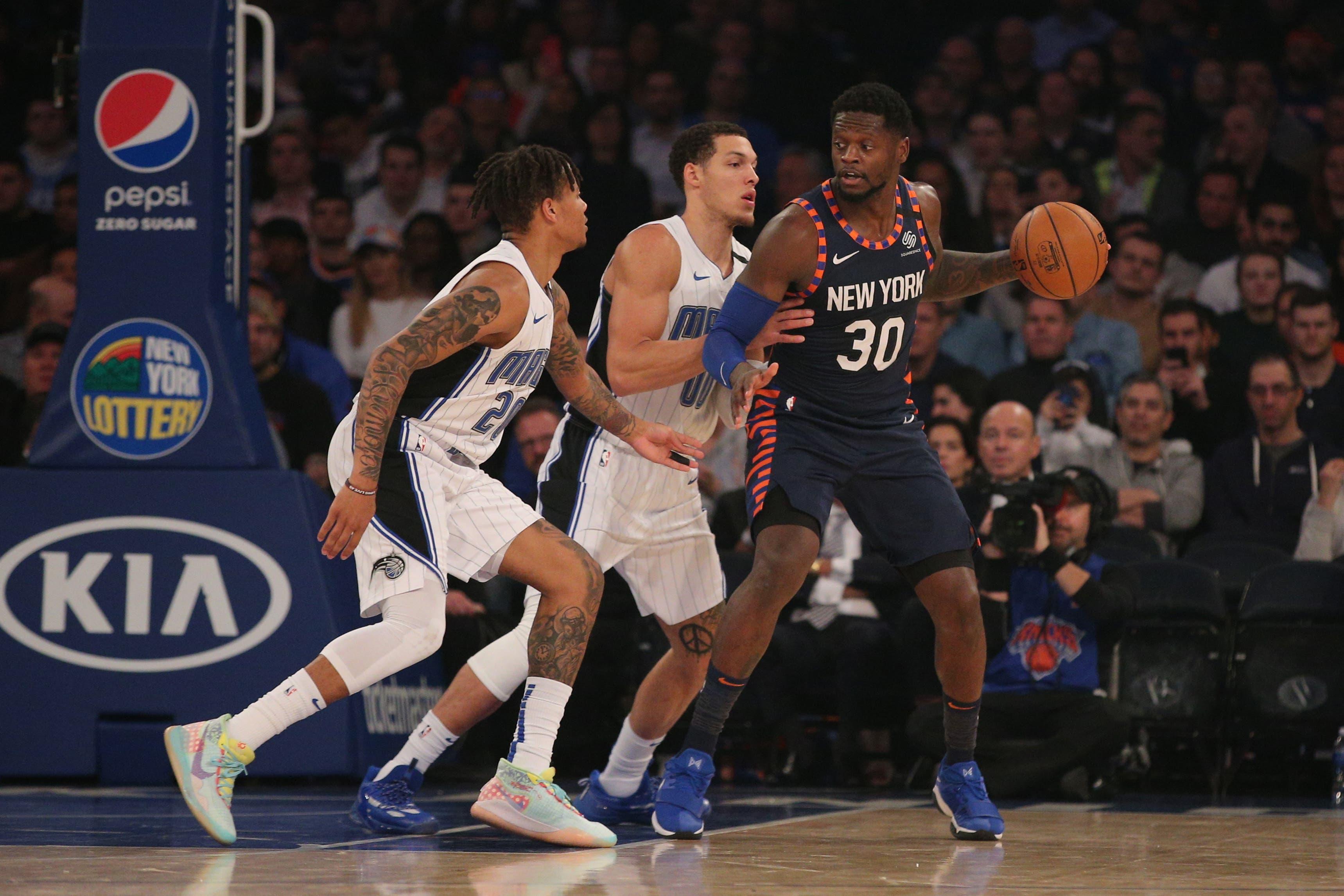 Feb 6, 2020; New York, New York, USA; New York Knicks power forward Julius Randle (30) controls the ball against Orlando Magic point guard Markelle Fultz (20) and power forward Aaron Gordon (00) during the second quarter at Madison Square Garden. Mandatory Credit: Brad Penner-USA TODAY Sports / Brad Penner