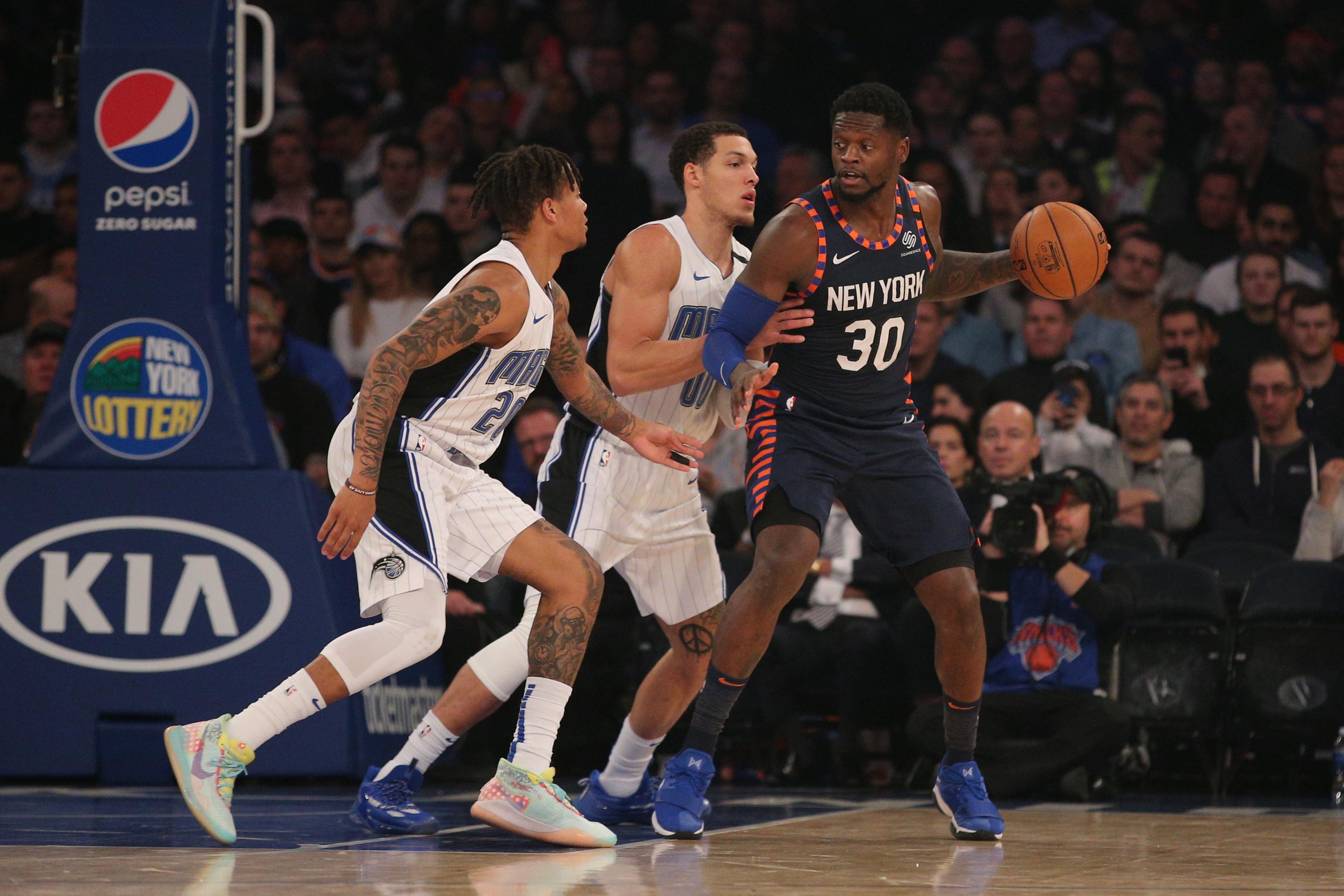 Feb 6, 2020; New York, New York, USA; New York Knicks power forward Julius Randle (30) controls the ball against Orlando Magic point guard Markelle Fultz (20) and power forward Aaron Gordon (00) during the second quarter at Madison Square Garden. Mandatory Credit: Brad Penner-USA TODAY Sports