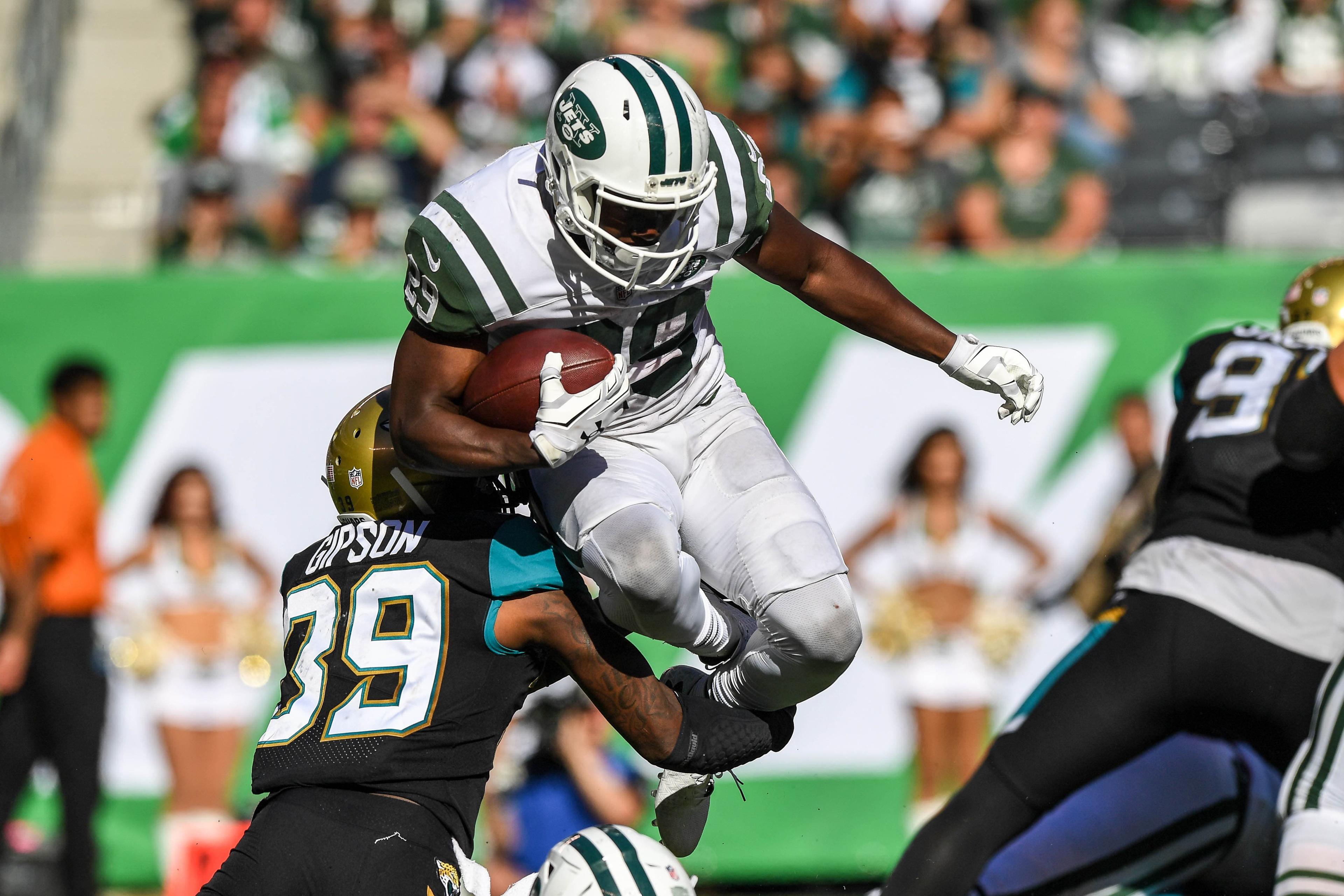 New York Jets running back Bilal Powell leaps over Jacksonville Jaguars free safety Tashaun Gipson during the third quarter at MetLife Stadium. / Dennis Schneidler/USA TODAY Sports