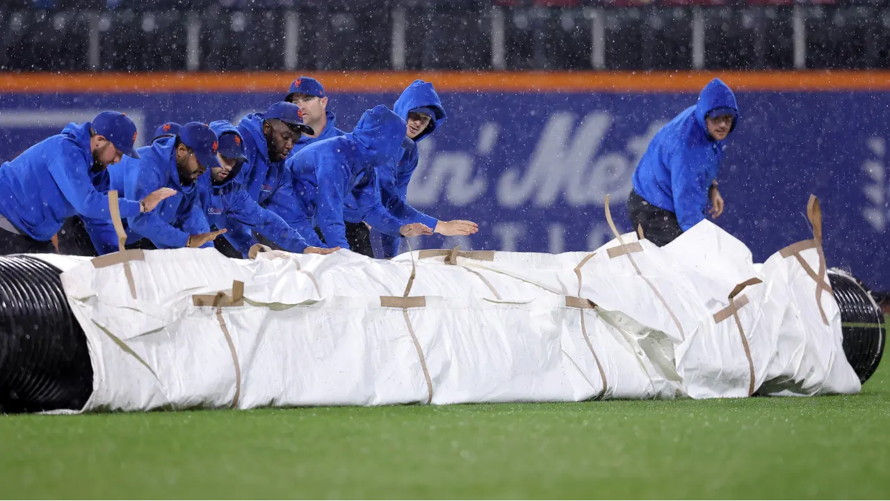 New York Mets grounds crew roll out the tarp during a rain delay at Citi Field. / Brad Penner-USA TODAY Sports