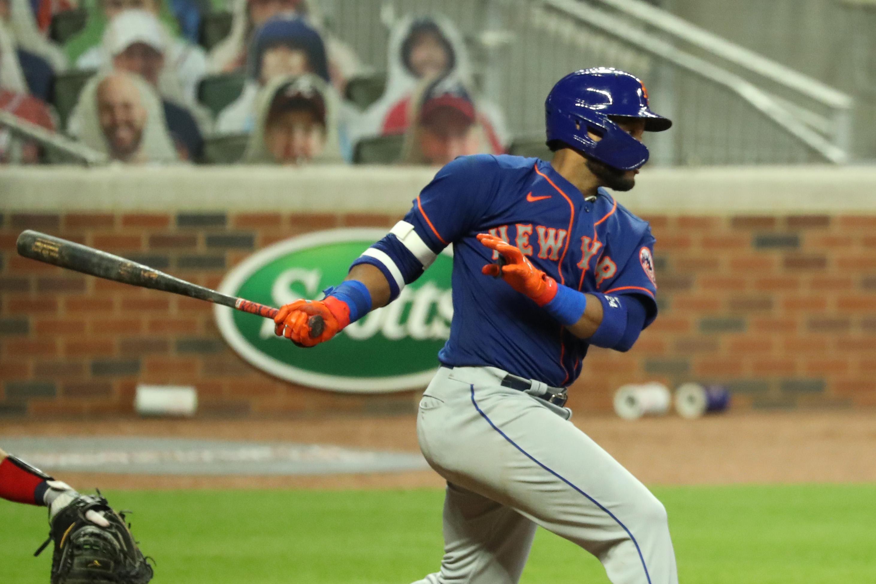 New York Mets second baseman Robinson Cano (24) hits an RBI single in the fifth inning against the Atlanta Braves at Truist Park. / Jason Getz-USA TODAY Sports
