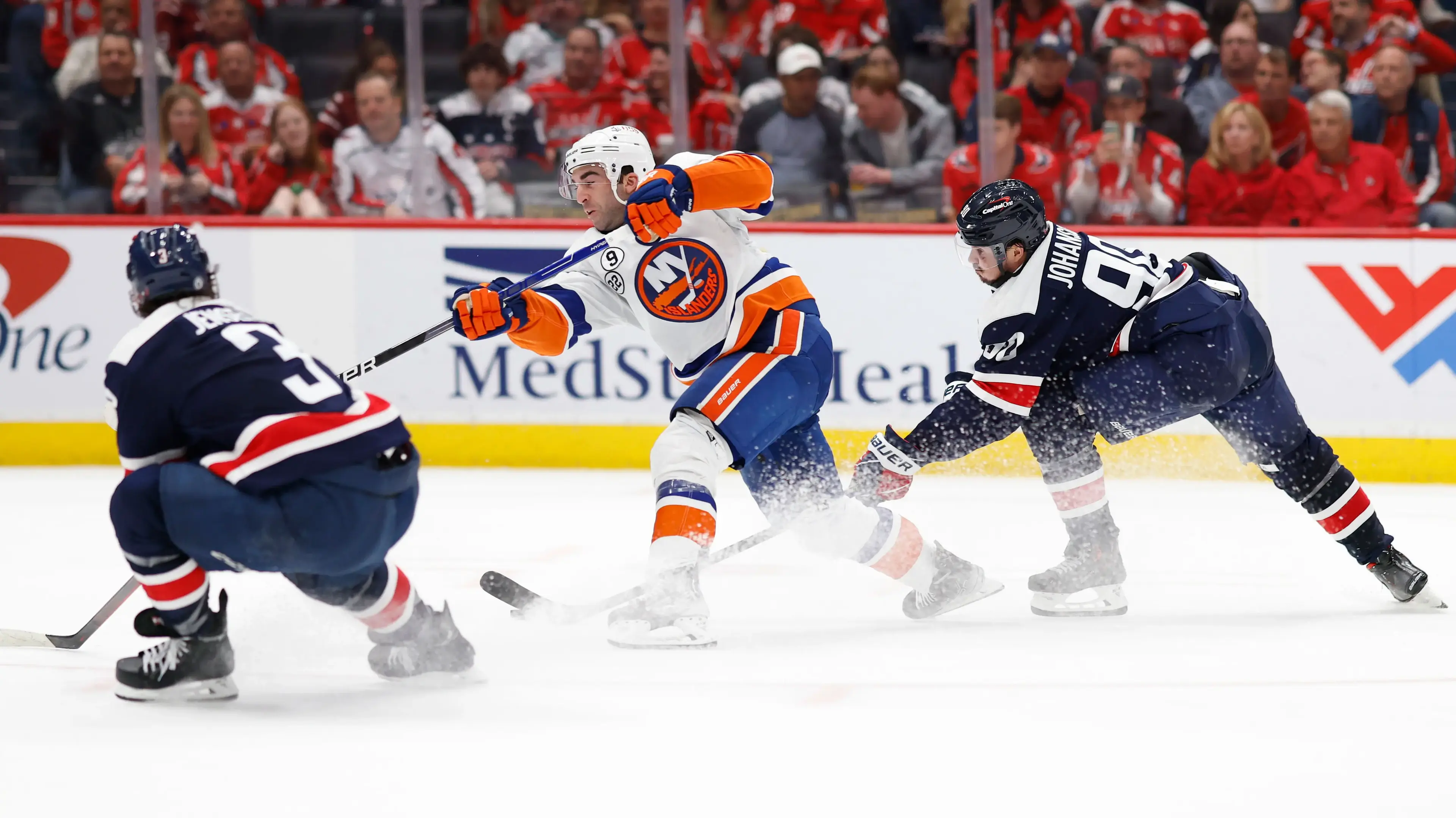 Apr 26, 2022; Washington, District of Columbia, USA; New York Islanders right wing Kyle Palmieri (21) shoots the puck as Washington Capitals defenseman Nick Jensen (3) and Capitals left wing Marcus Johansson (90) defend in the second period at Capital One Arena. / Geoff Burke-USA TODAY Sports