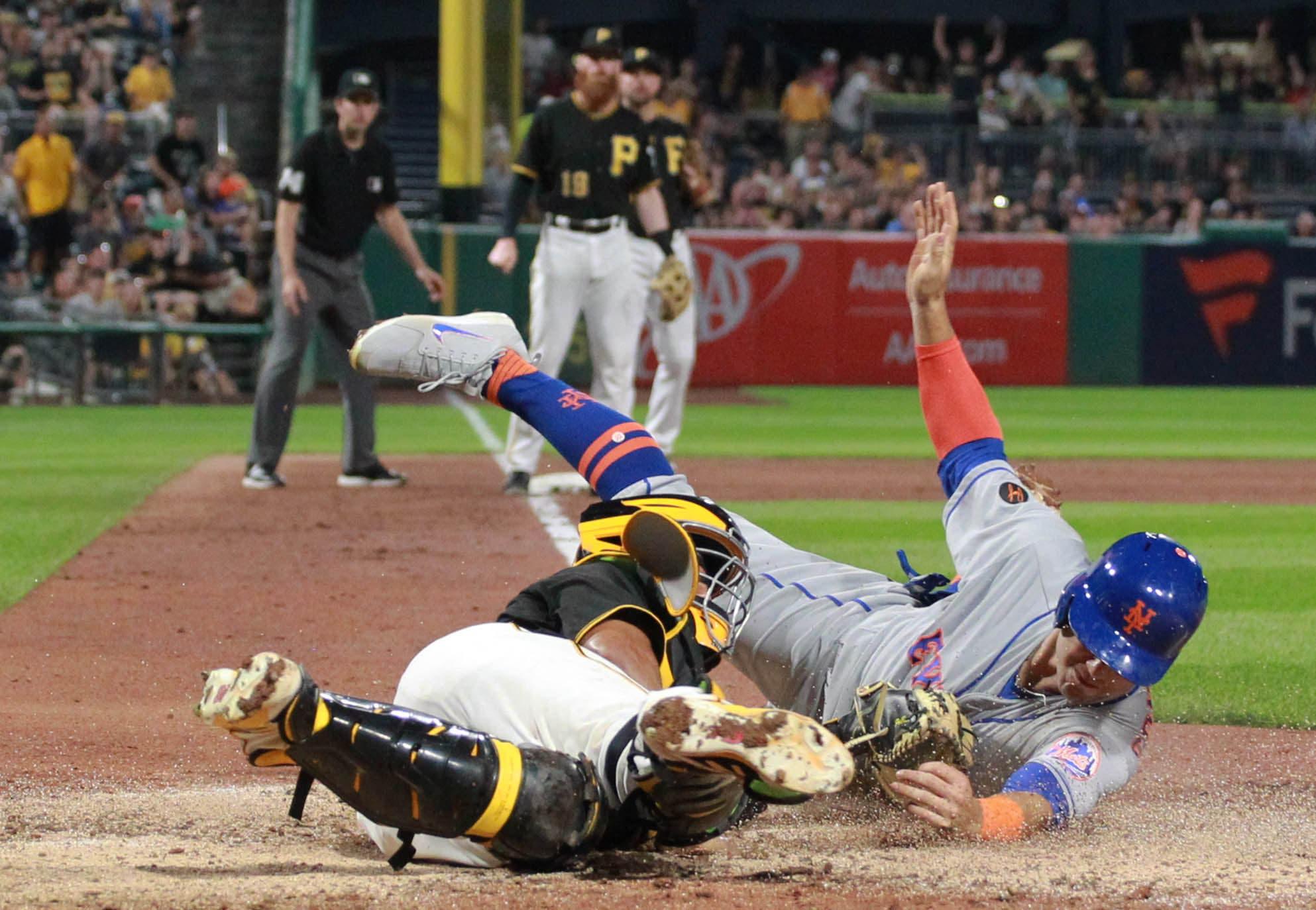 New York Mets left fielder Michael Conforto touches home plate to score a run ahead of a tag attempt by Pittsburgh Pirates catcher Elias Diaz during the sixth inning at PNC Park. / Charles LeClaire/USA TODAY Sports