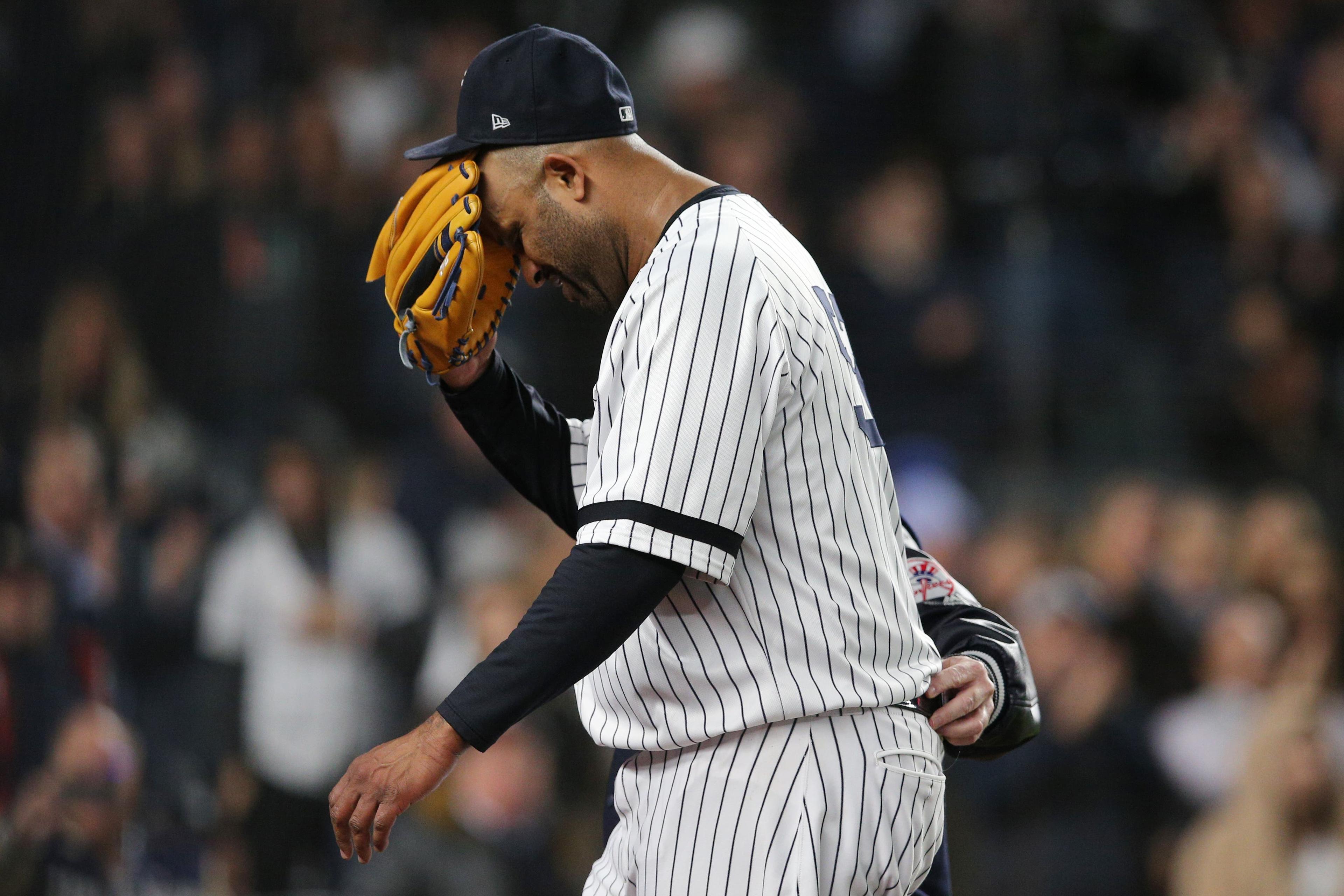 Oct 17, 2019; Bronx, NY, USA; New York Yankees pitcher CC Sabathia (52) reacts as he is walked off the field by trainer Steve Donohue after suffering an apparent injury against the Houston Astros during the eighth inning of game four of the 2019 ALCS playoff baseball series at Yankee Stadium. Mandatory Credit: Brad Penner-USA TODAY Sports / Brad Penner