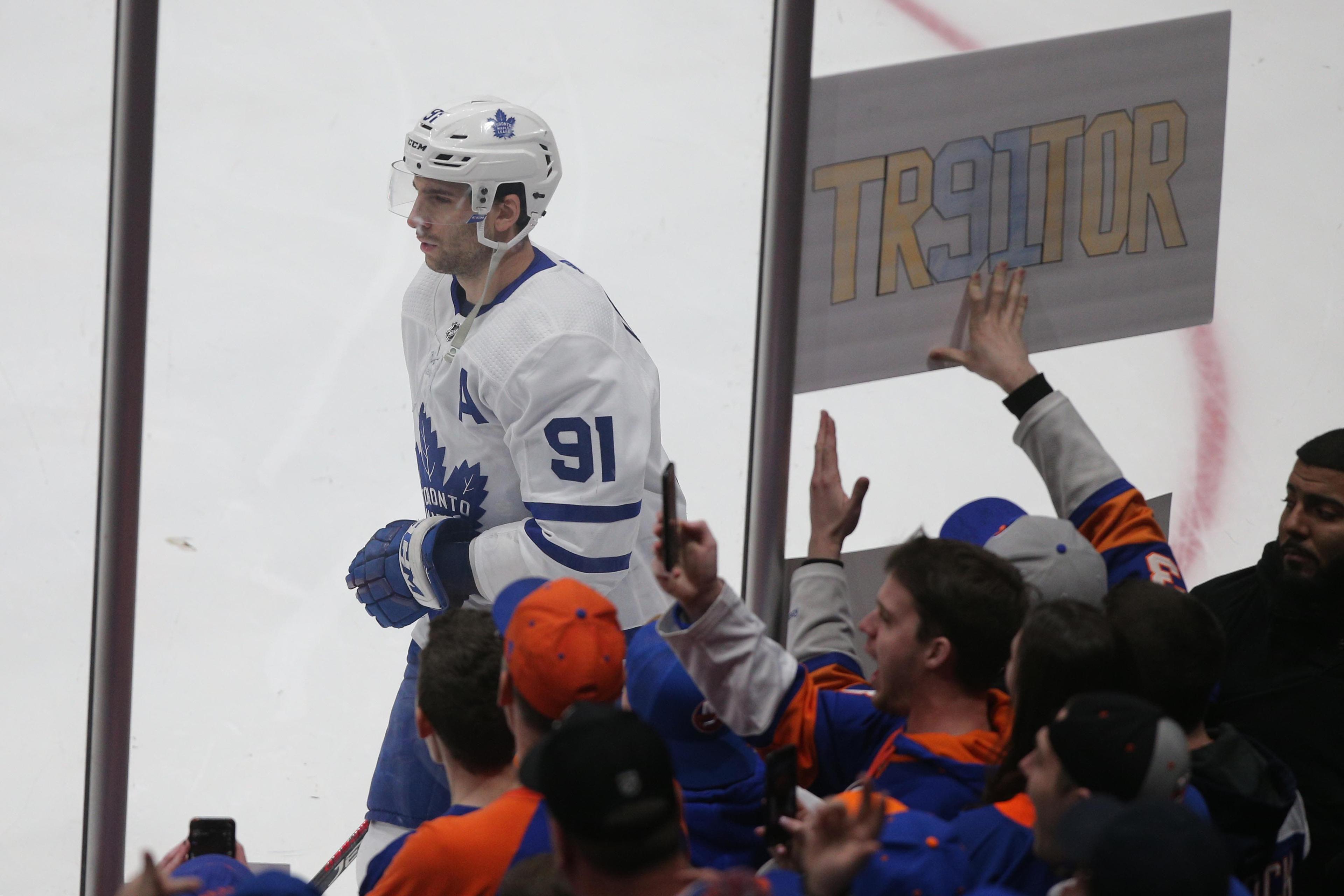 Feb 28, 2019; Brooklyn, NY, USA; Toronto Maple Leafs center John Tavares (91) skates past a sign held by a fan of the New York Islanders during warm ups before a game at the Nassau Veterans Memorial Coliseum. Mandatory Credit: Brad Penner-USA TODAY Sports / Brad Penner