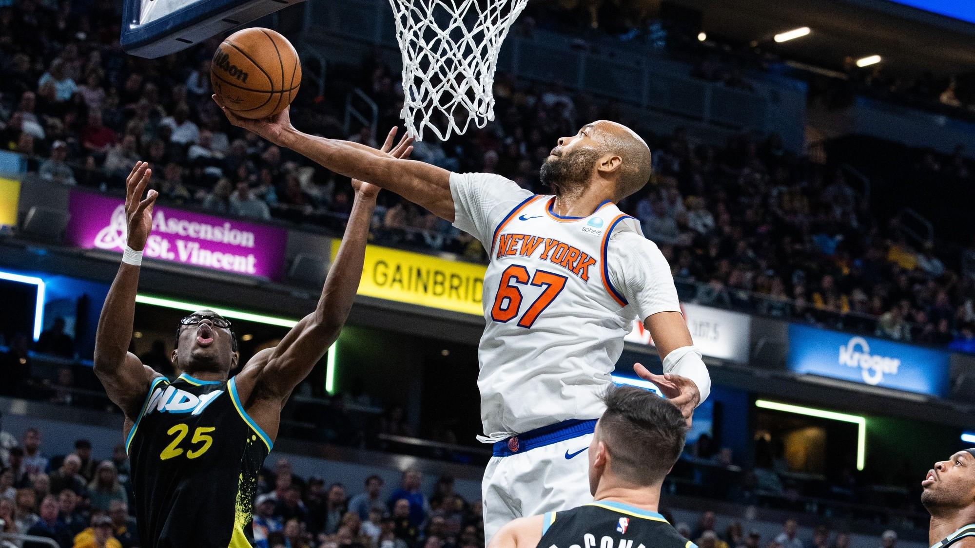 Dec 30, 2023; Indianapolis, Indiana, USA; New York Knicks forward Taj Gibson (67) rebounds the ball while Indiana Pacers forward Jalen Smith (25) defends in the second half at Gainbridge Fieldhouse. / Trevor Ruszkowski-USA TODAY Sports