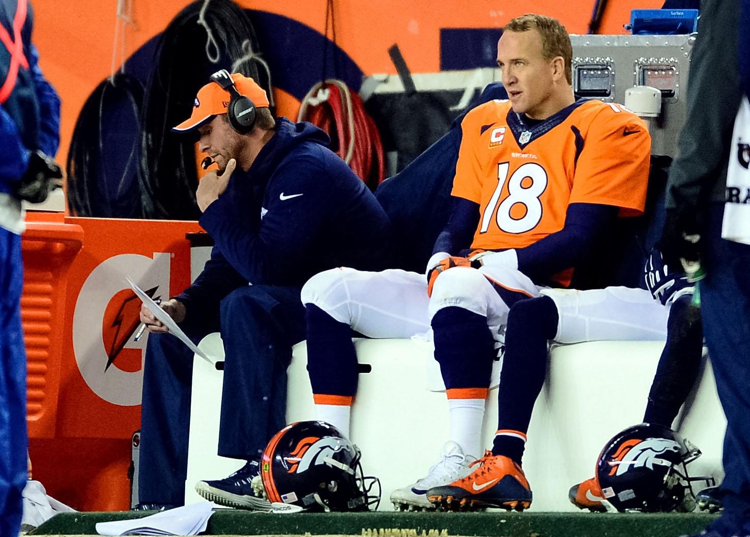  Jan 11, 2015; Denver, CO, USA; Denver Broncos quarterback Peyton Manning (18) and offensive coordinator Adam Gase on the sideline during the fourth quarter in the 2014 AFC Divisional playoff football game at Sports Authority Field at Mile High. Mandatory Credit: Ron Chenoy-USA TODAY Sports