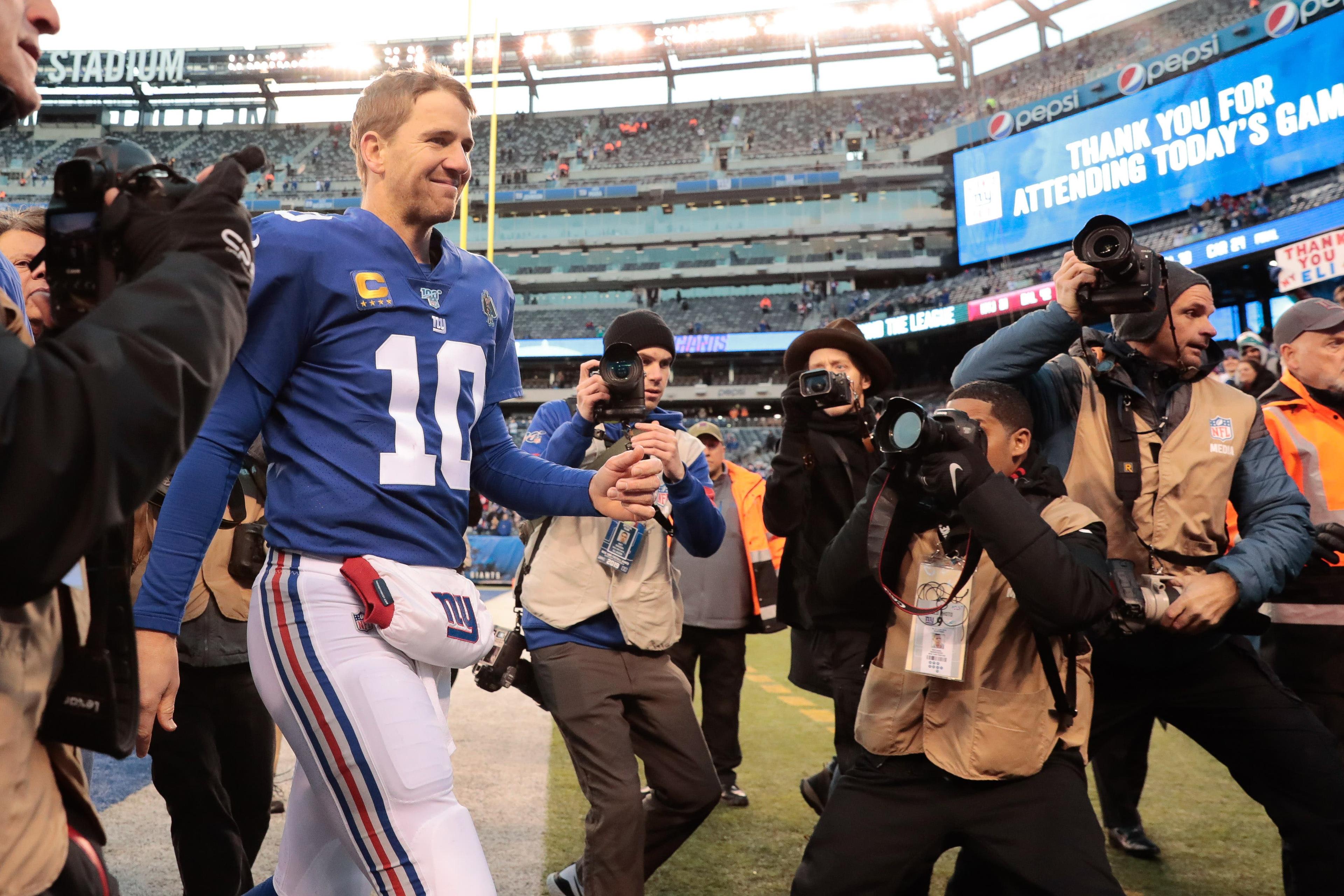 Dec 15, 2019; East Rutherford, NJ, USA; New York Giants quarterback Eli Manning (10) leaves the field followed by media game after his game against the Miami Dolphins at MetLife Stadium. Mandatory Credit: Vincent Carchietta-USA TODAY Sportsundefined