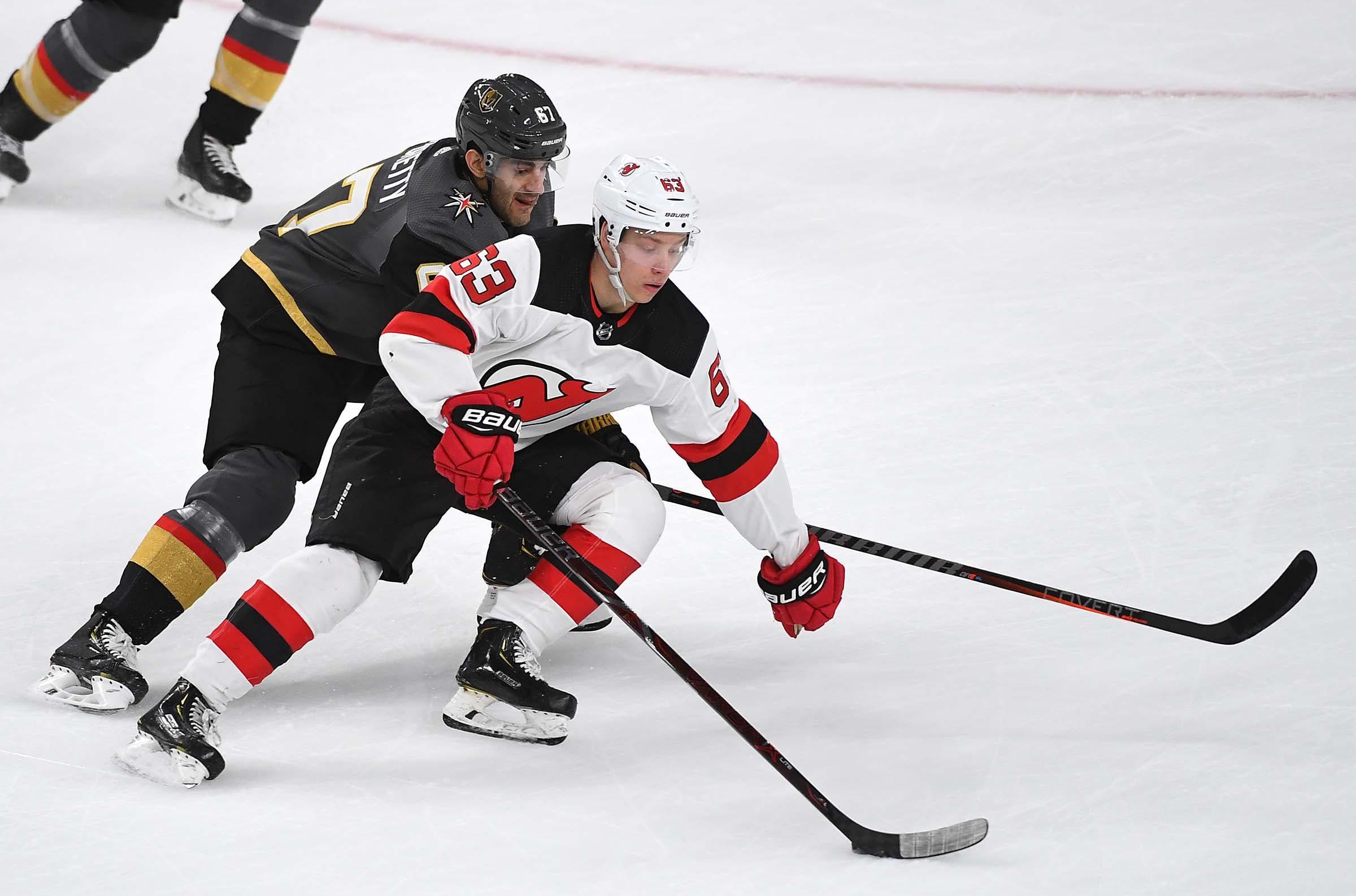 New Jersey Devils left wing Jesper Bratt protects the puck from Vegas Golden Knights left wing Max Pacioretty during the first period at T-Mobile Arena. / Stephen R. Sylvanie/USA TODAY Sports