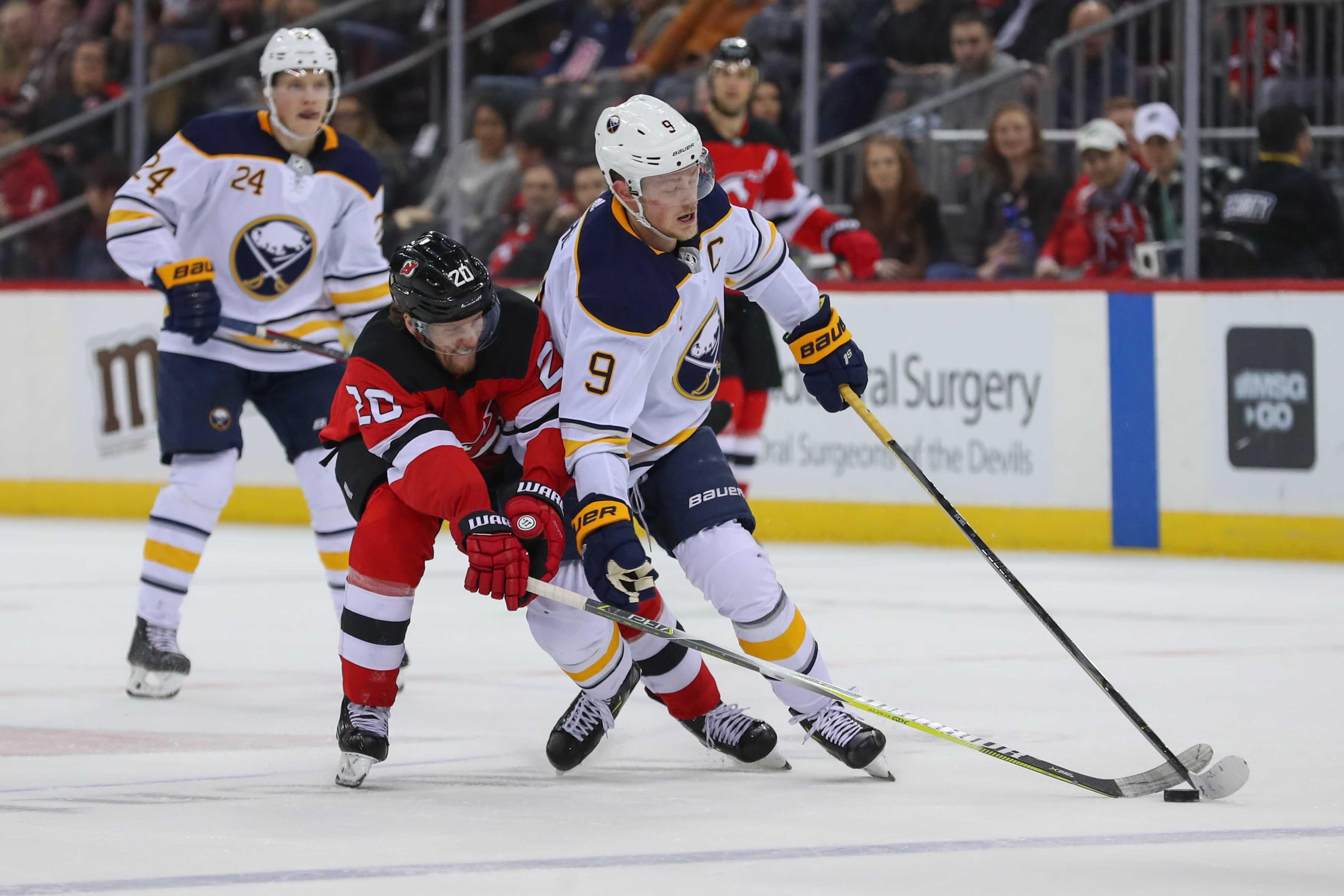 Buffalo Sabres center Jack Eichel skates with the puck while being defended by New Jersey Devils center Blake Coleman during the first period at Prudential Center. / Ed Mulholland/USA TODAY Sports