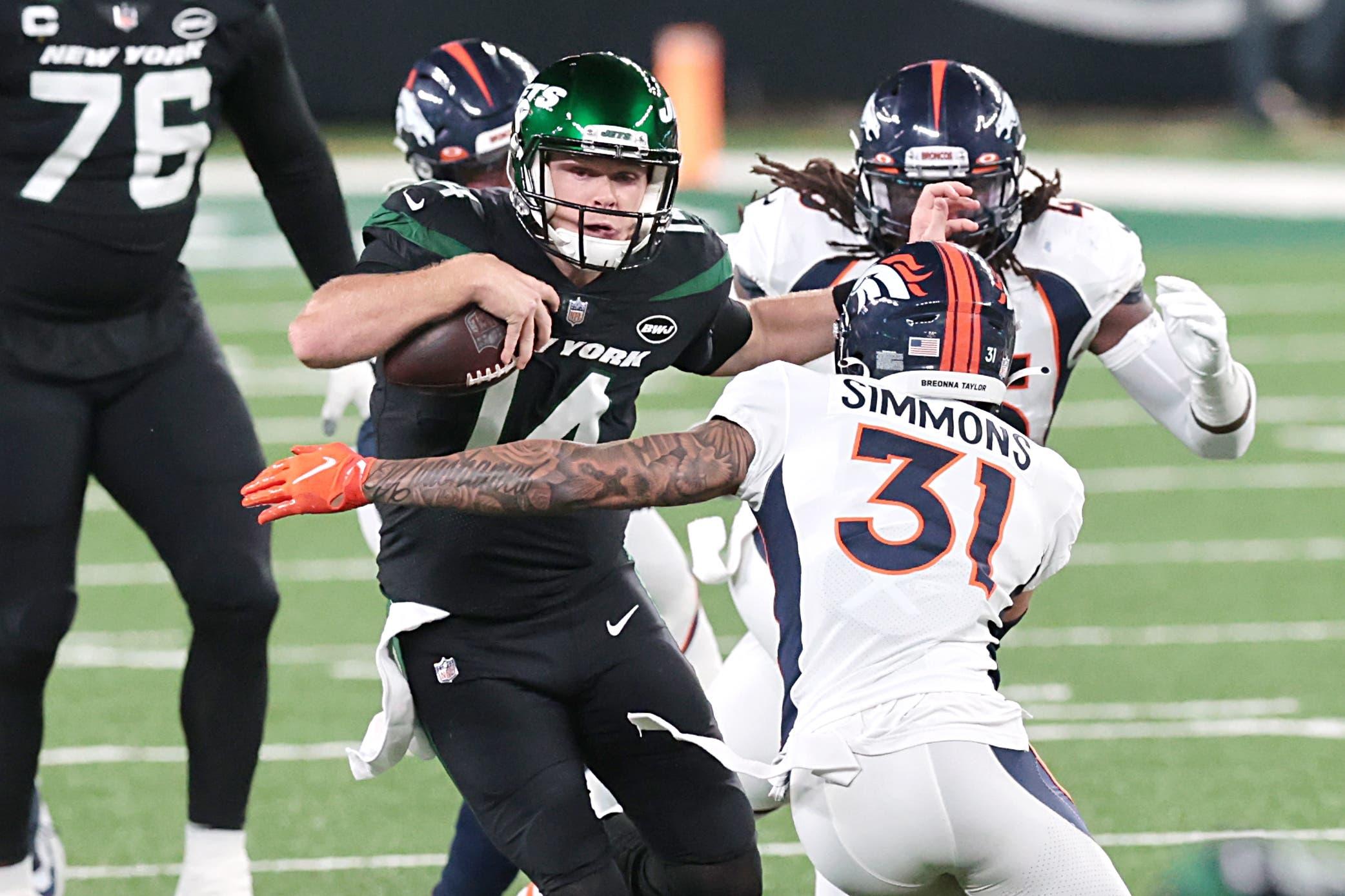 New York Jets quarterback Sam Darnold (14) breaks a tackle by Denver Broncos free safety Justin Simmons (31) for a touchdown at MetLife Stadium. / Vincent Carchietta - USA TODAY Sports