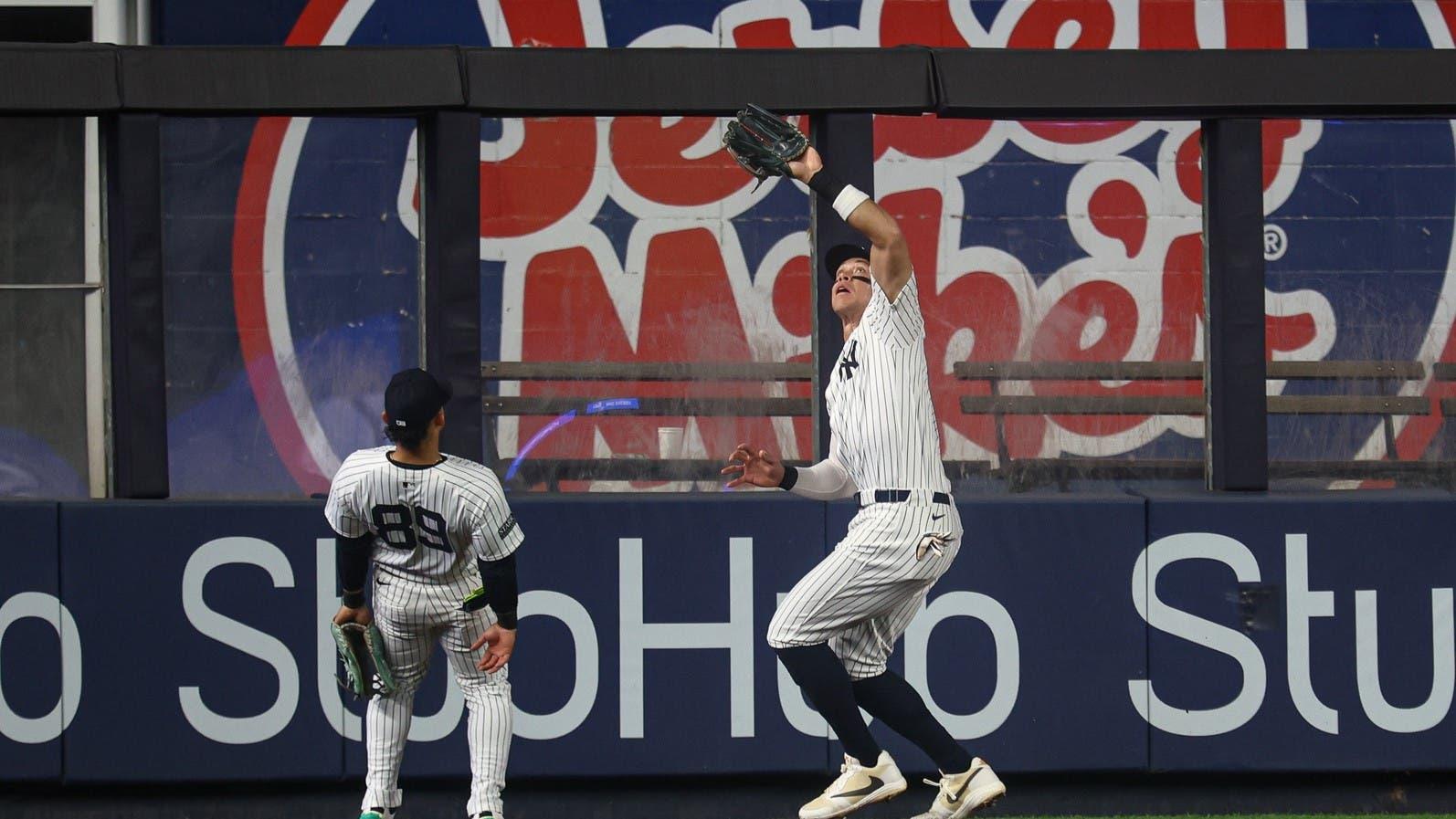 Sep 26, 2024; Bronx, New York, USA; New York Yankees center fielder Aaron Judge (99) makes a catch for an out in front of left fielder Jasson Dominguez (89) during the first inning against the Baltimore Orioles at Yankee Stadium. / Vincent Carchietta-Imagn Images