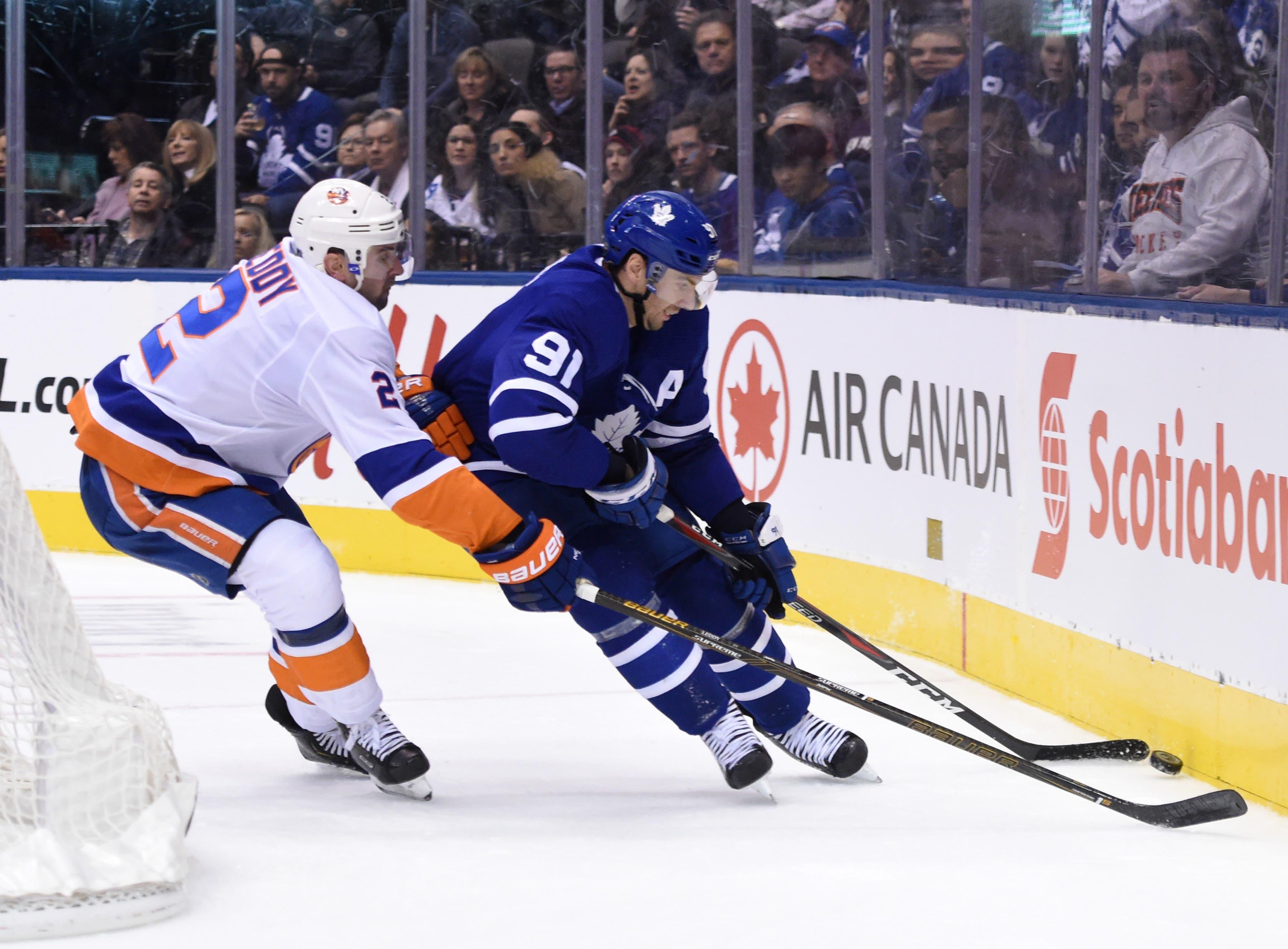 Toronto Maple Leafs forward John Tavares battles for the puck against New York Islanders defenseman Nick Leddy in the second period at Scotiabank Arena. / Dan Hamilton/USA TODAY Sports