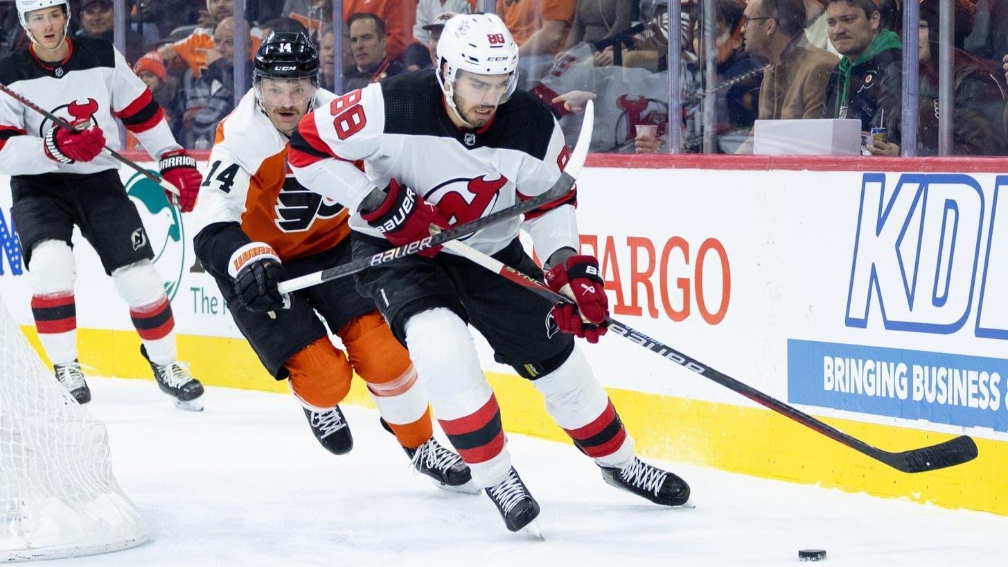 Nov 30, 2023; Philadelphia, Pennsylvania, USA; New Jersey Devils defenseman Kevin Bahl (88) is high sticked by Philadelphia Flyers center Sean Couturier (14) while skating with the puck during the first period at Wells Fargo Center. / Bill Streicher-USA TODAY Sports