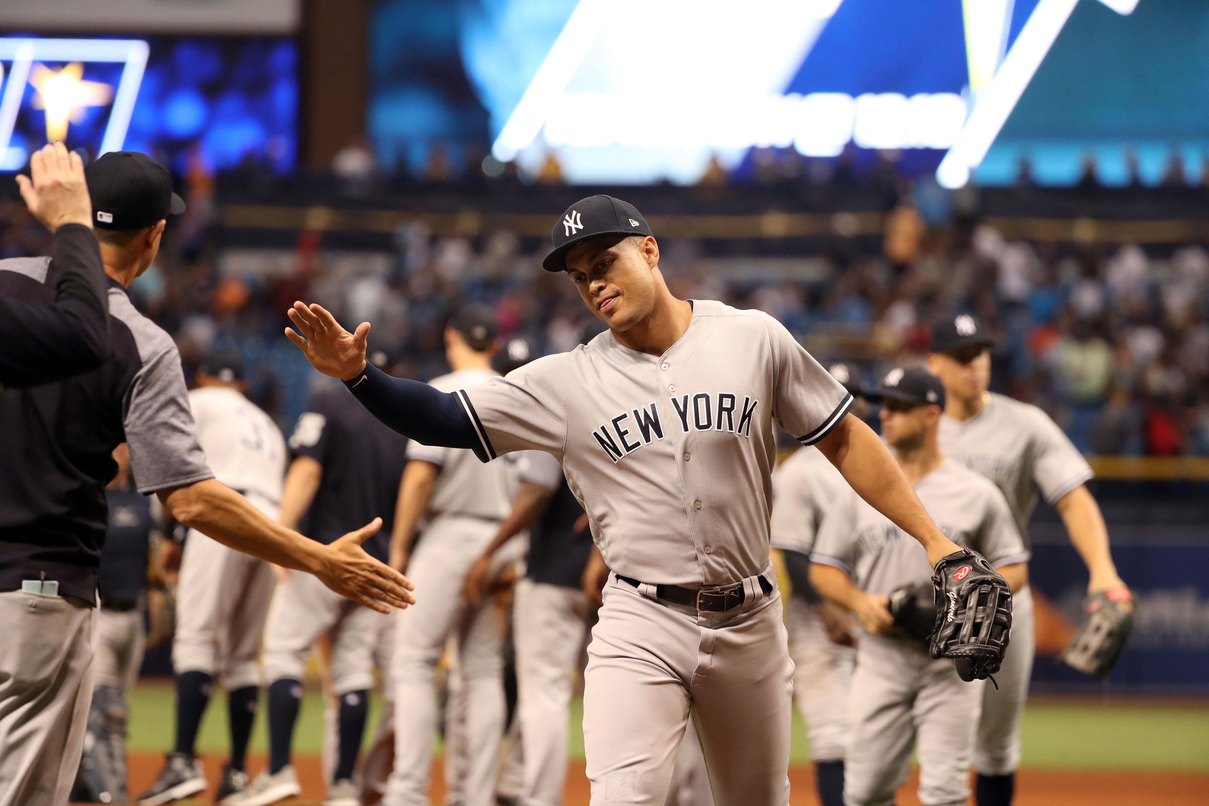 Jul 24, 2018; St. Petersburg, FL, USA; New York Yankees designated hitter Giancarlo Stanton (27) high fives as they beat the Tampa Bay Rays at Tropicana Field. Mandatory Credit: Kim Klement-USA TODAY Sports / Kim Klement