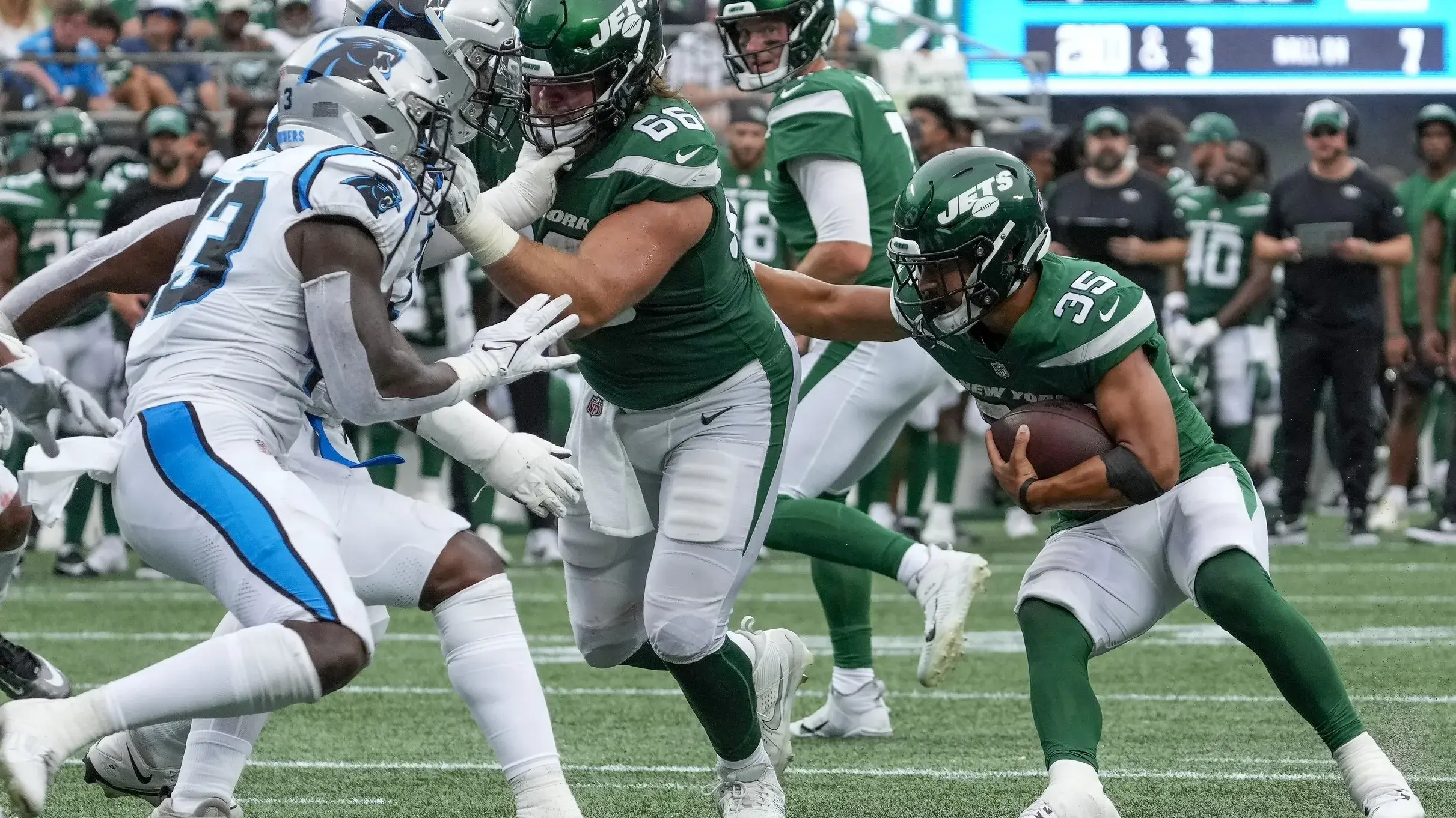 Aug 12, 2023; Charlotte, North Carolina, USA; New York Jets running back Travis Dye (35) follows the block by center Joe Tippmann (66) during the second half against the Carolina Panthers at Bank of America Stadium. / Jim Dedmon-USA TODAY Sports