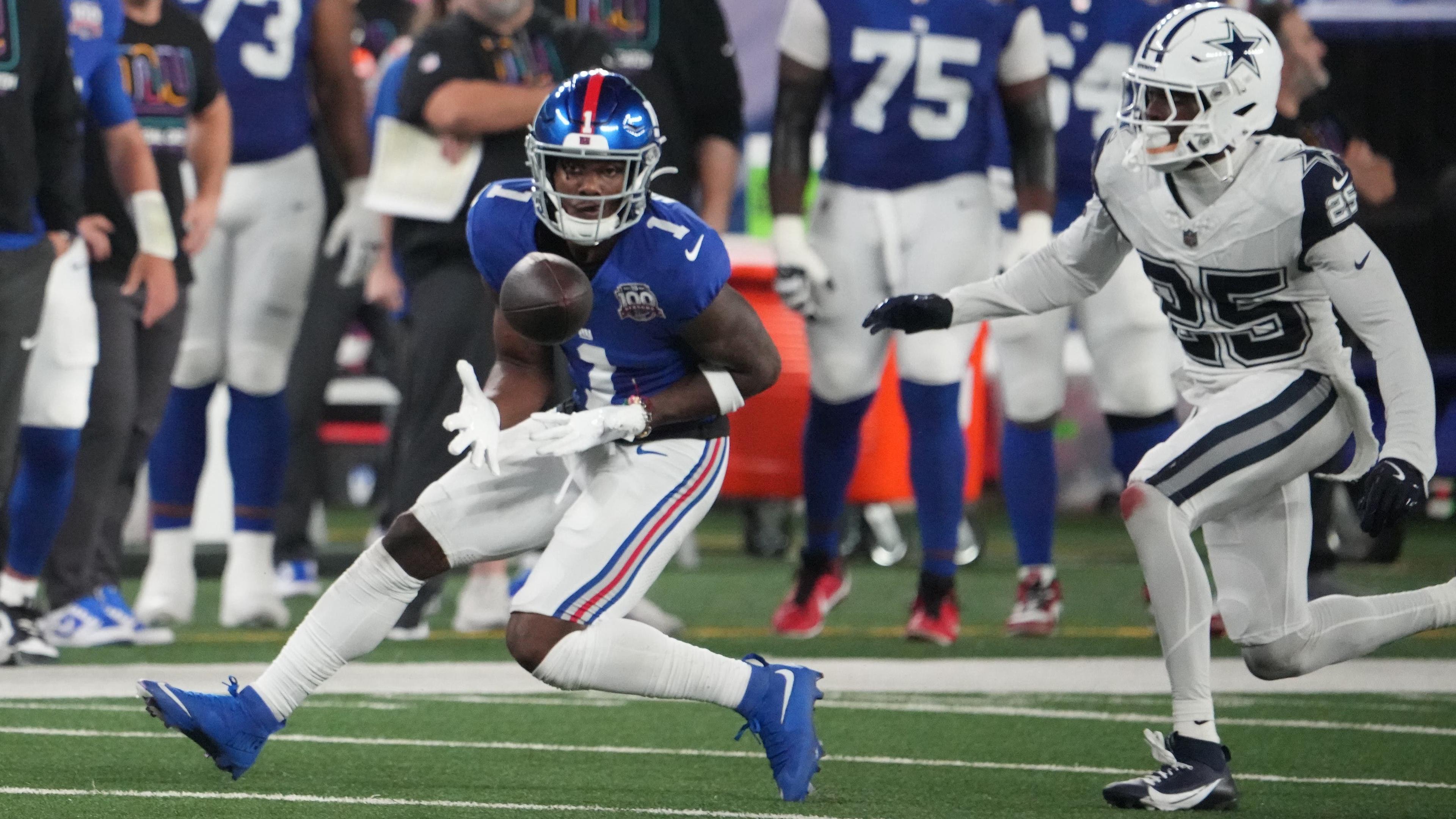 Sep 26, 2024; East Rutherford, New Jersey, USA; New York Giants wide receiver Malik Nabers (1) gathers in a pass in front of Dallas Cowboys cornerback Andrew Booth Jr. (25) in the first half at MetLife Stadium. Mandatory Credit: Robert Deutsch-Imagn Images