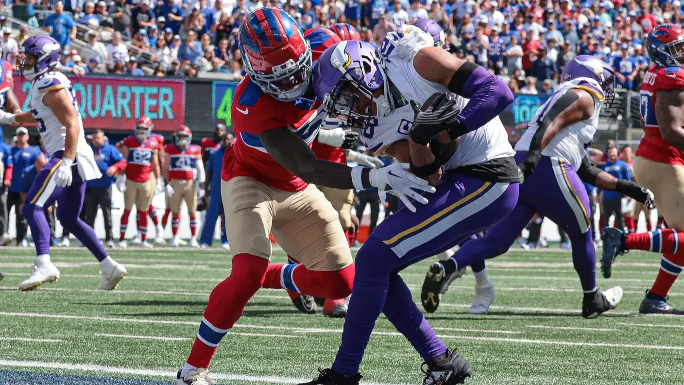 Sep 8, 2024; East Rutherford, New Jersey, USA; Minnesota Vikings wide receiver Justin Jefferson (18) catches a touchdown pass as New York Giants cornerback Deonte Banks (3) defends during the first half at MetLife Stadium. / Vincent Carchietta-Imagn Images