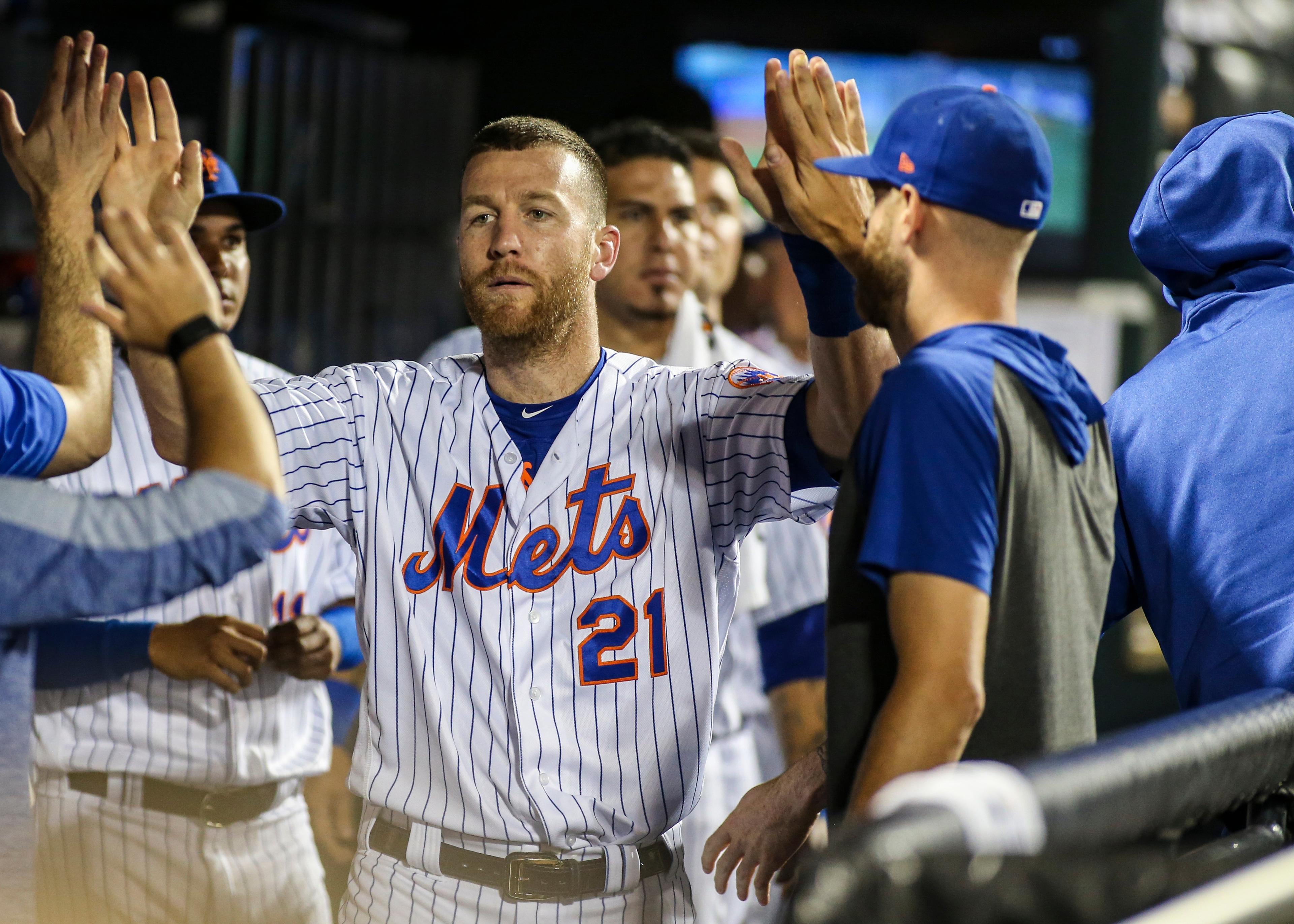 Aug 21, 2019; New York City, NY, USA; New York Mets third baseman Todd Frazier (21) is greeted in the dugout after scoring against the Cleveland Indians in the fifth inning at Citi Field. Mandatory Credit: Wendell Cruz-USA TODAY Sports