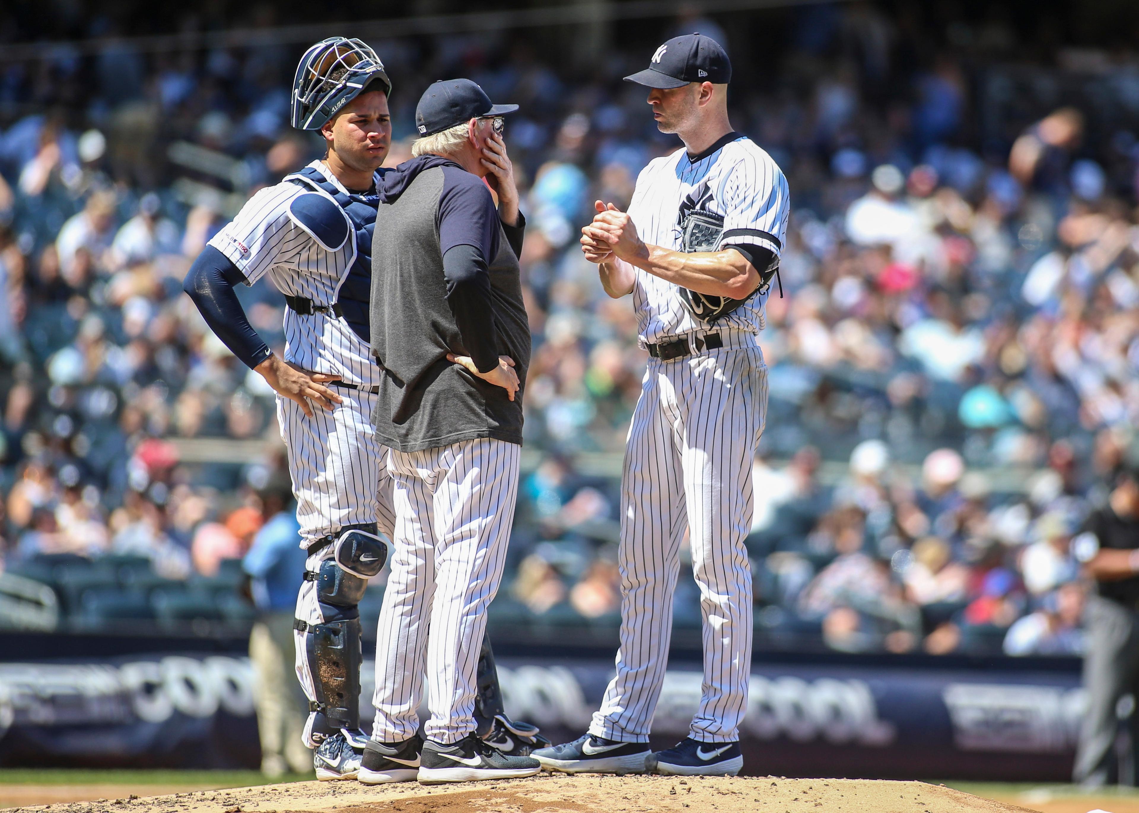 Jun 23, 2019; Bronx, NY, USA; New York Yankees catcher Gary Sanchez (24) and pitching coach Larry Rothschild (58) have a mound conference with pitcher J.A. Happ (34) in the fourth inning at Yankee Stadium. Mandatory Credit: Wendell Cruz-USA TODAY Sports