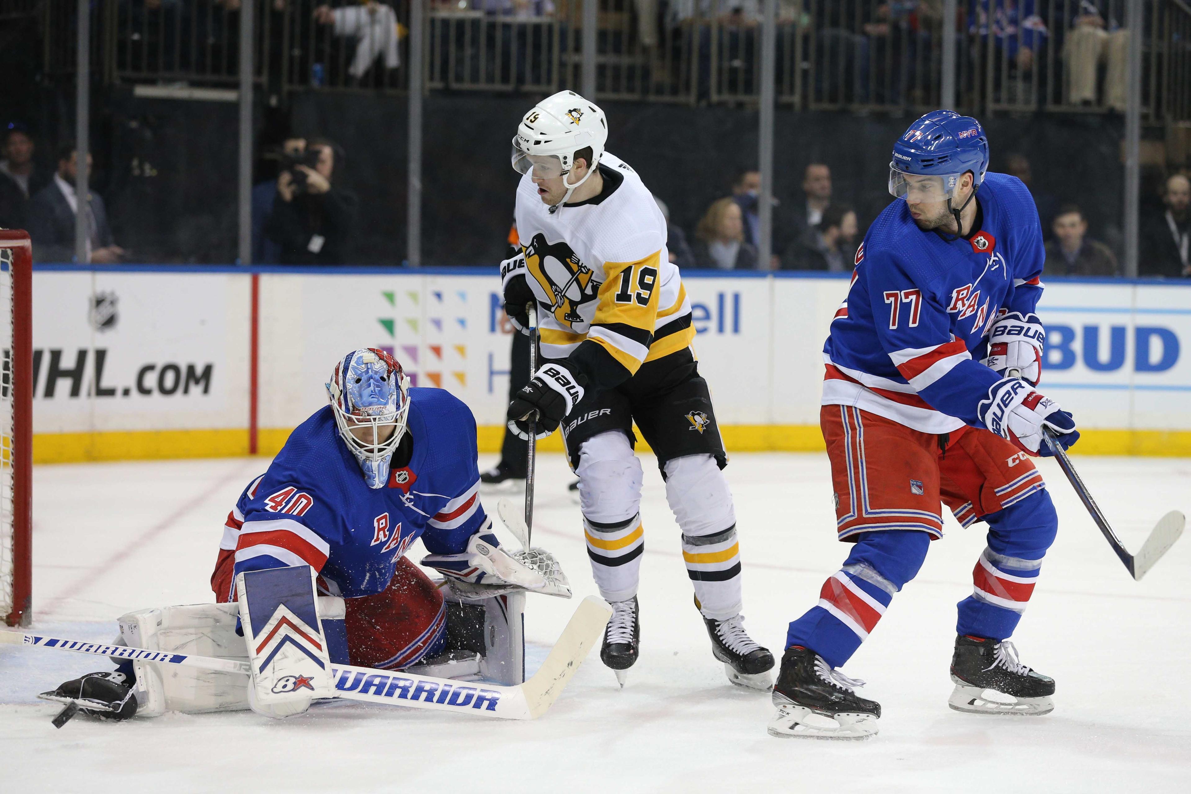 New York Rangers goalie Alexandar Georgiev makes a save in front of Pittsburgh Penguins center Jared McCann and Rangers defenseman Tony DeAngelo during the first period at Madison Square Garden. / Brad Penner/USA TODAY Sports