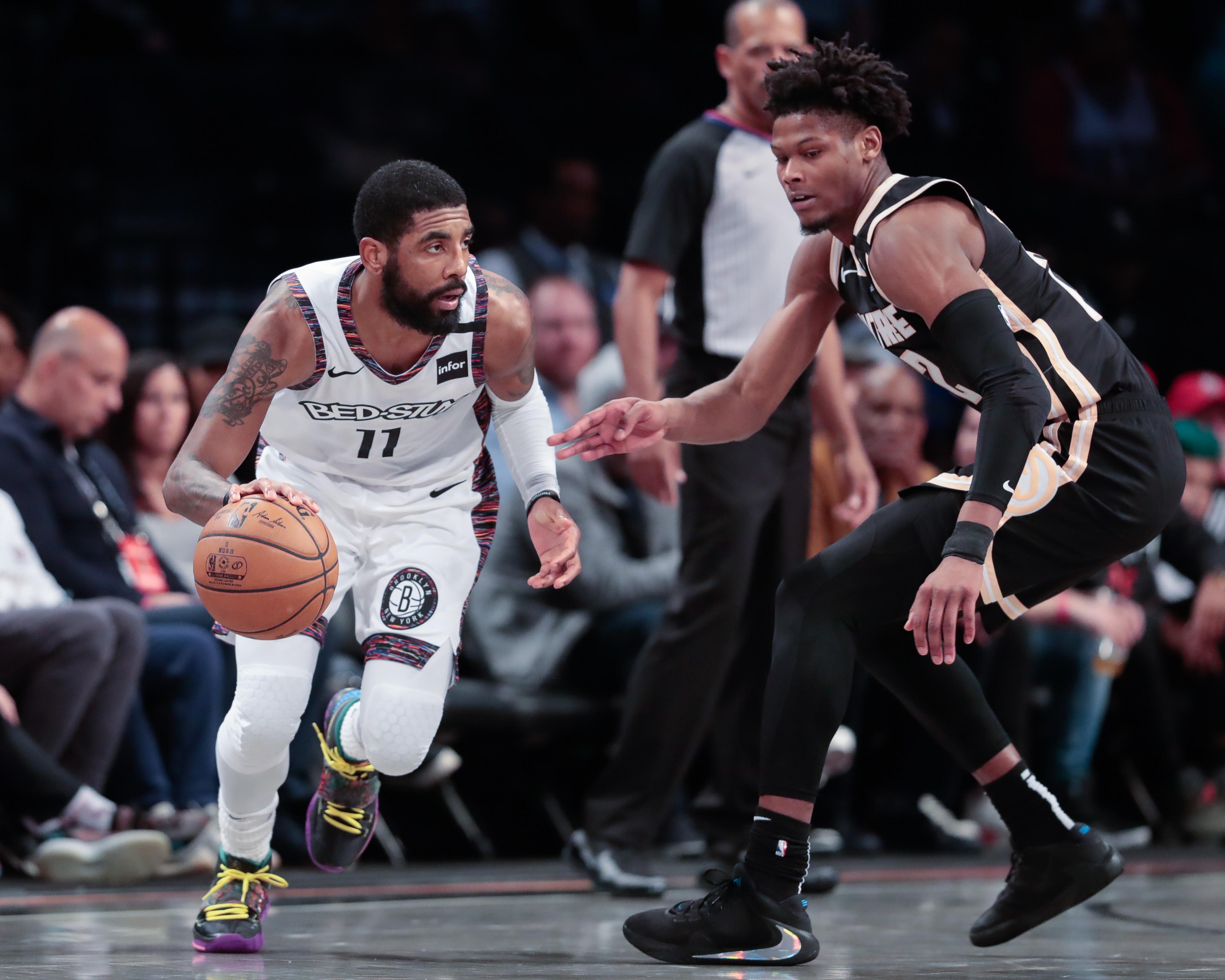 Jan 12, 2020; Brooklyn, New York, USA; Brooklyn Nets guard Kyrie Irving (11) dribbles as Atlanta Hawks forward Cam Reddish (22) defends during the second quarter at Barclays Center. Mandatory Credit: Vincent Carchietta-USA TODAY Sports