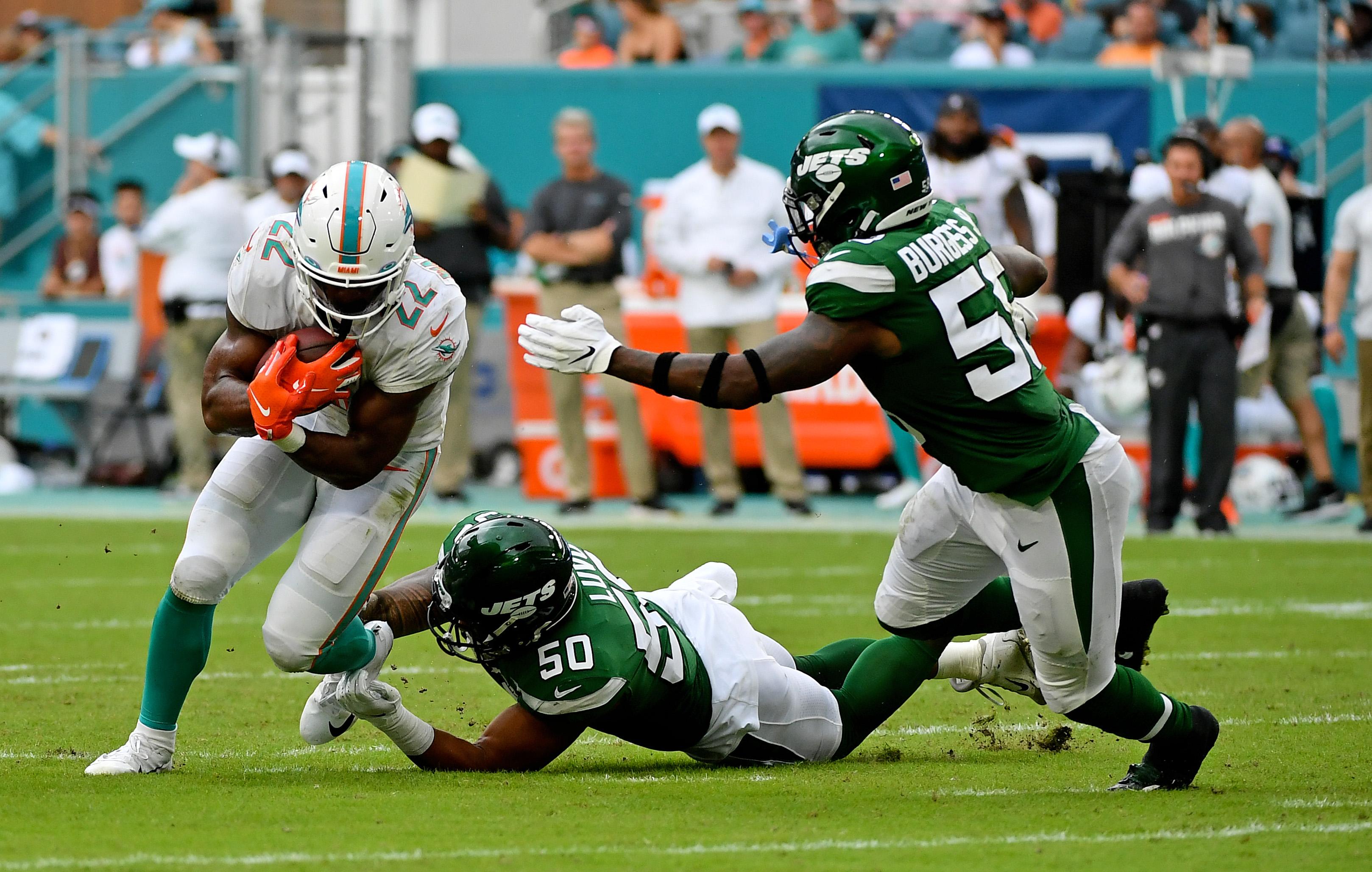 Nov 3, 2019; Miami Gardens, FL, USA; Miami Dolphins running back Mark Walton (22) runs the ball past New York Jets linebacker Frankie Luvu (50) and outside linebacker James Burgess (58) during the first half at Hard Rock Stadium. Mandatory Credit: Jasen Vinlove-USA TODAY Sports