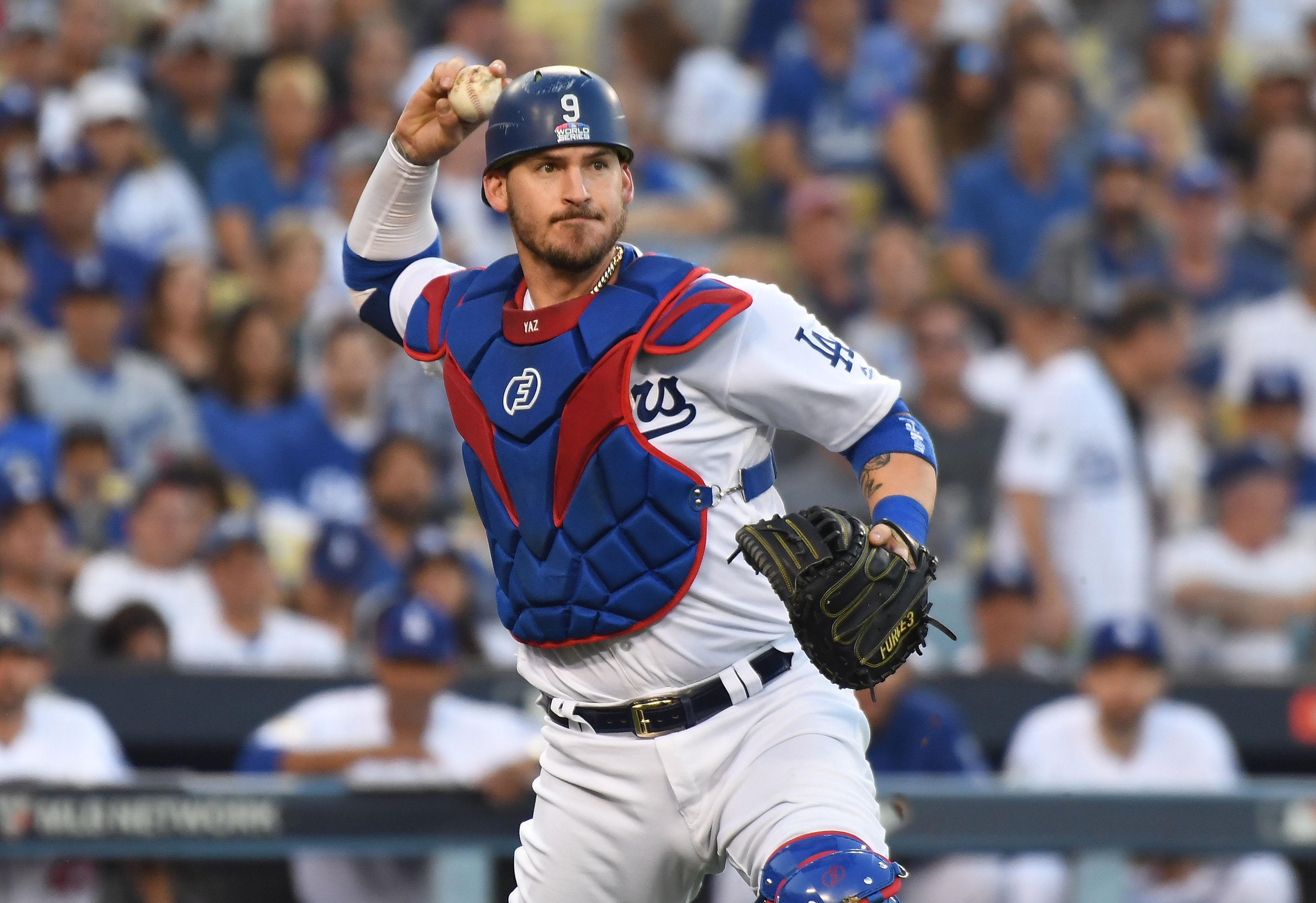 Oct 26, 2018; Los Angeles, CA, USA; Los Angeles Dodgers catcher Yasmani Grandal (9) throws to first for an out against Boston Red Sox second baseman Brock Holt (not pictured) in the second inning in game three of the 2018 World Series at Dodger Stadium. Mandatory Credit: Richard Mackson-USA TODAY Sports