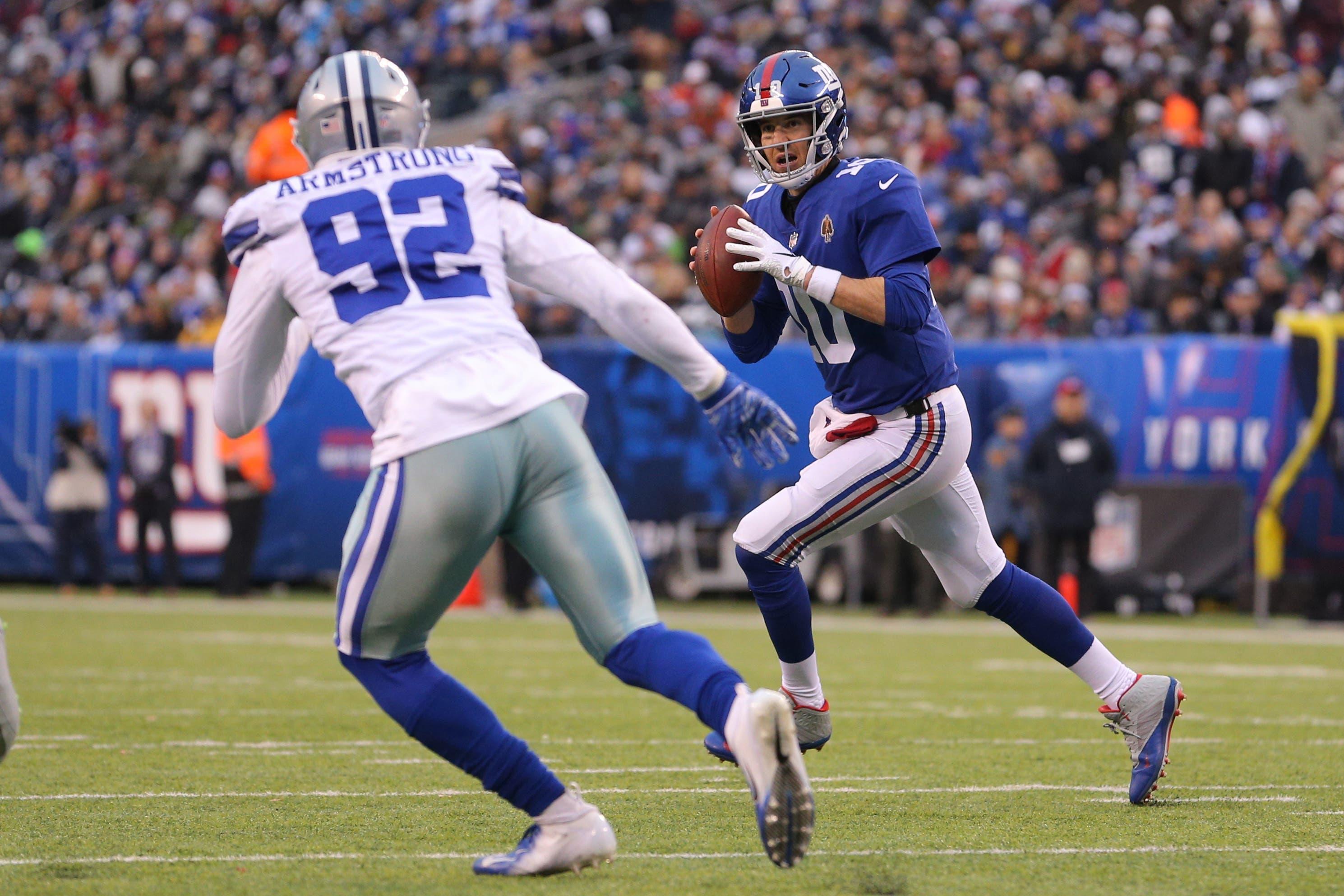 New York Giants quarterback Eli Manning looks to pass against Dallas Cowboys defensive end Dorance Armstrong during the third quarter at MetLife Stadium. / Brad Penner/USA TODAY Sports