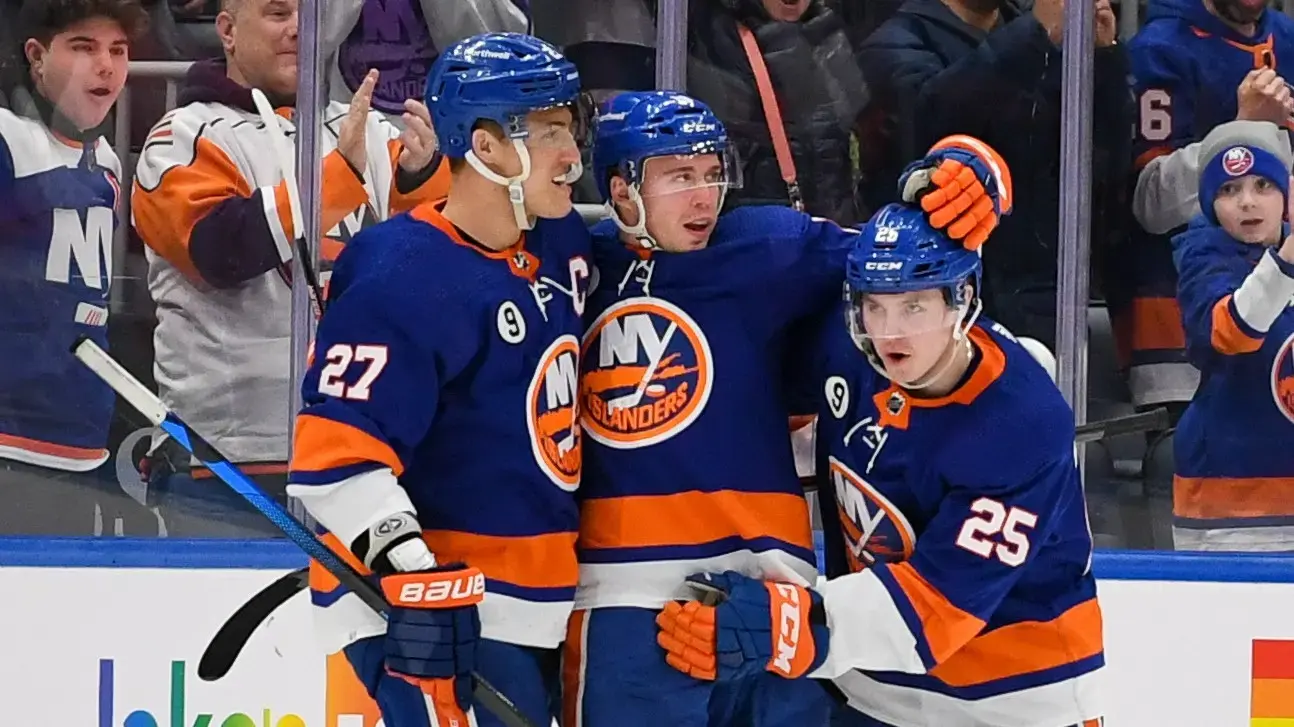 Mar 3, 2022; Elmont, New York, USA; New York Islanders defenseman Sebastian Aho (25) and left wing Anders Lee (27) celebrates the goal by right wing Josh Bailey (12) against the Vancouver Canucks during the third period at UBS Arena. Mandatory Credit: Dennis Schneidler-USA TODAY Sports / Dennis Schneidler-USA TODAY Sports