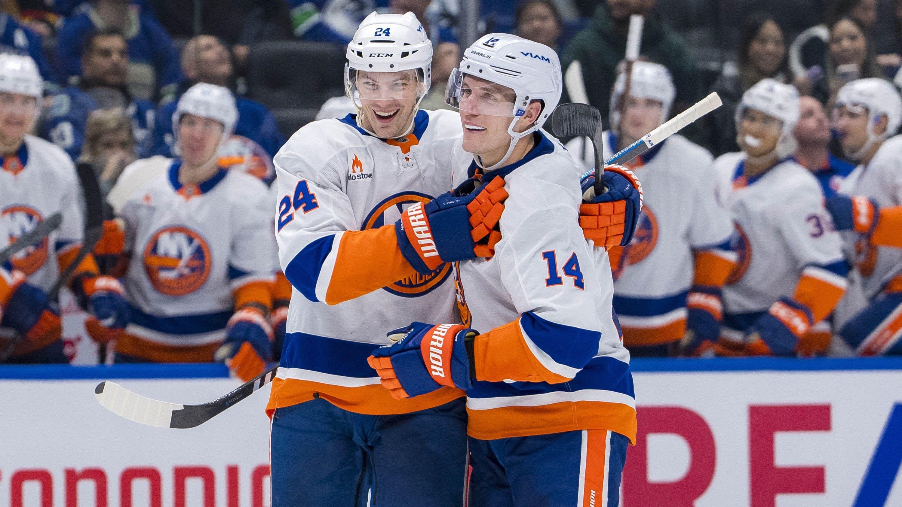 Nov 14, 2024; Vancouver, British Columbia, CAN; New York Islanders defenseman Scott Mayfield (24) and forward Bo Horvat (14) celebrate Mayfield’s goal against the Vancouver Canucks during the second period at Rogers Arena. / Bob Frid-Imagn Images