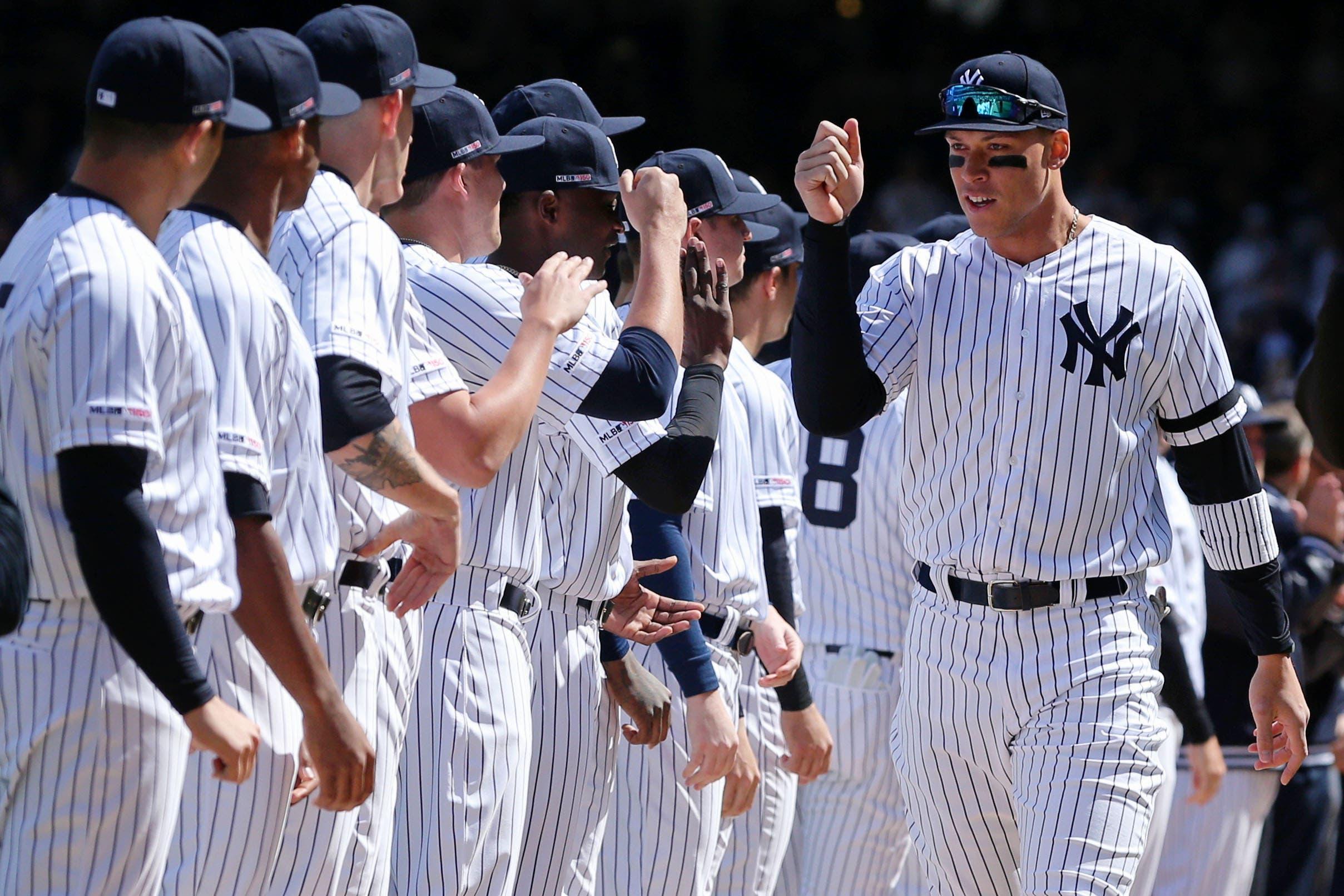 Mar 28, 2019; Bronx, NY, USA; New York Yankees right fielder Aaron Judge (99) high fives teammates after being introduced before an opening day game against the Baltimore Orioles at Yankee Stadium. Mandatory Credit: Brad Penner-USA TODAY Sports / Brad Penner