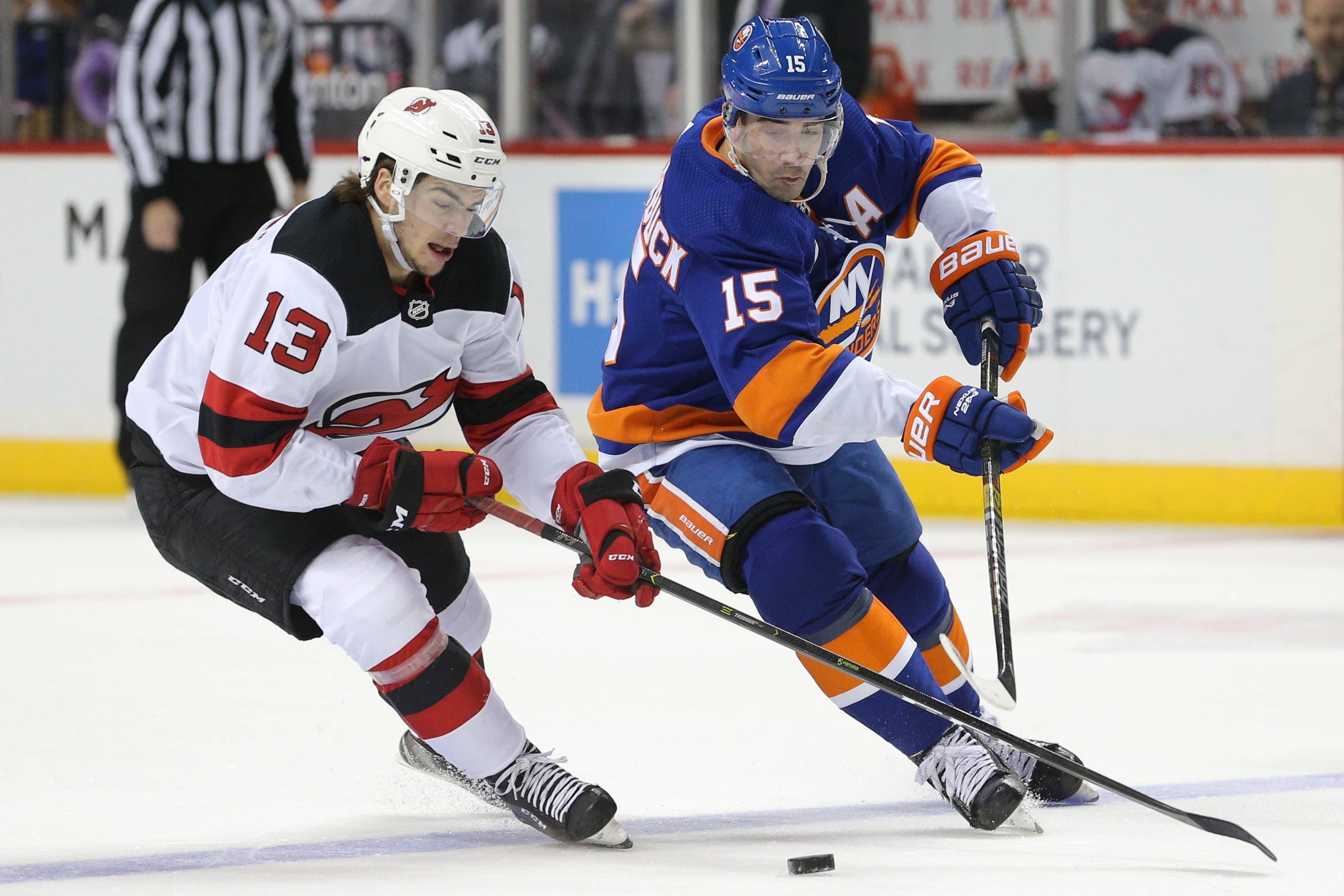 Nov 3, 2018; Brooklyn, NY, USA; New Jersey Devils center Nico Hischier (13) and New York Islanders right wing Cal Clutterbuck (15) fight for the puck during the second period at Barclays Center. Mandatory Credit: Brad Penner-USA TODAY Sports / Brad Penner