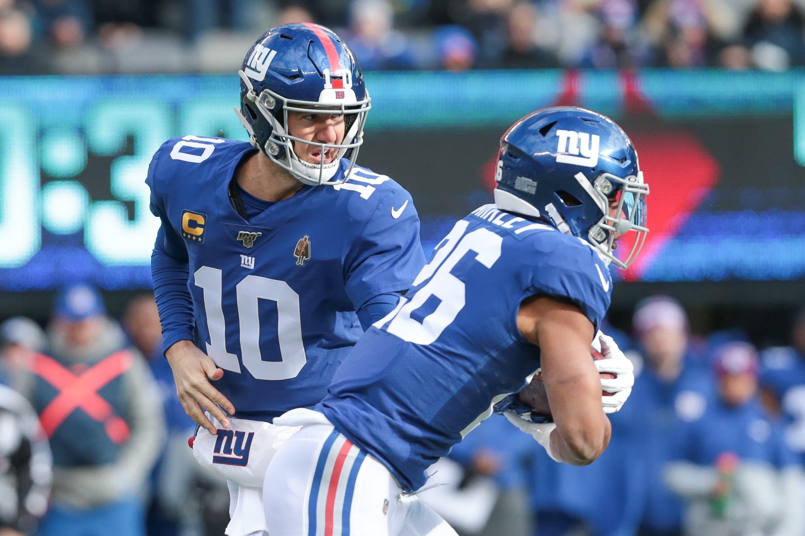 Dec 15, 2019; East Rutherford, NJ, USA; New York Giants quarterback Eli Manning (10) hands off to running back Saquon Barkley (26) during the first quarter against the Miami Dolphins at MetLife Stadium. Mandatory Credit: Vincent Carchietta-USA TODAY Sports / Vincent Carchietta