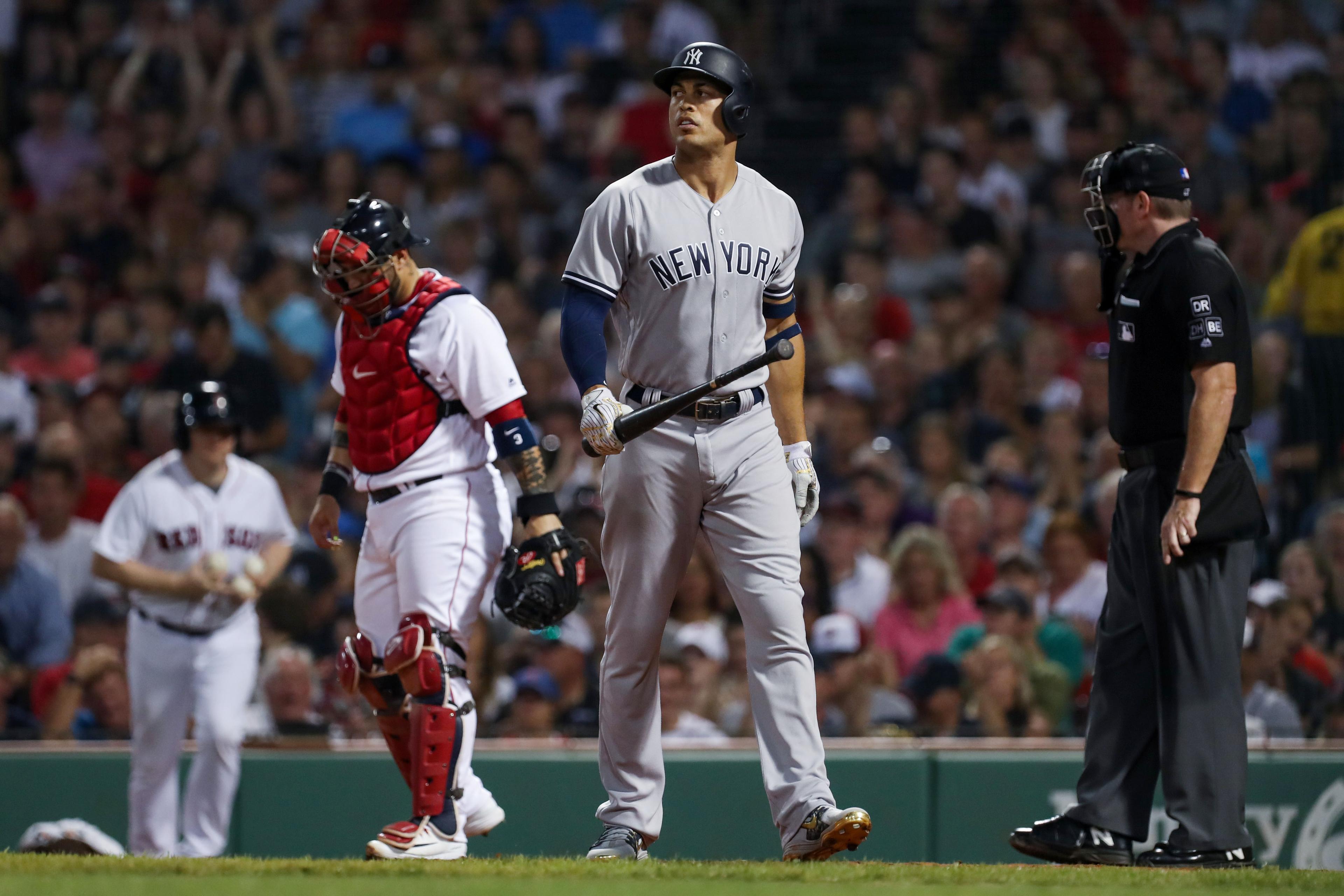 New York Yankees designated hitter Giancarlo Stanton walks back to the dugout after striking out against Boston Red Sox starting pitcher David Price at Fenway Park.